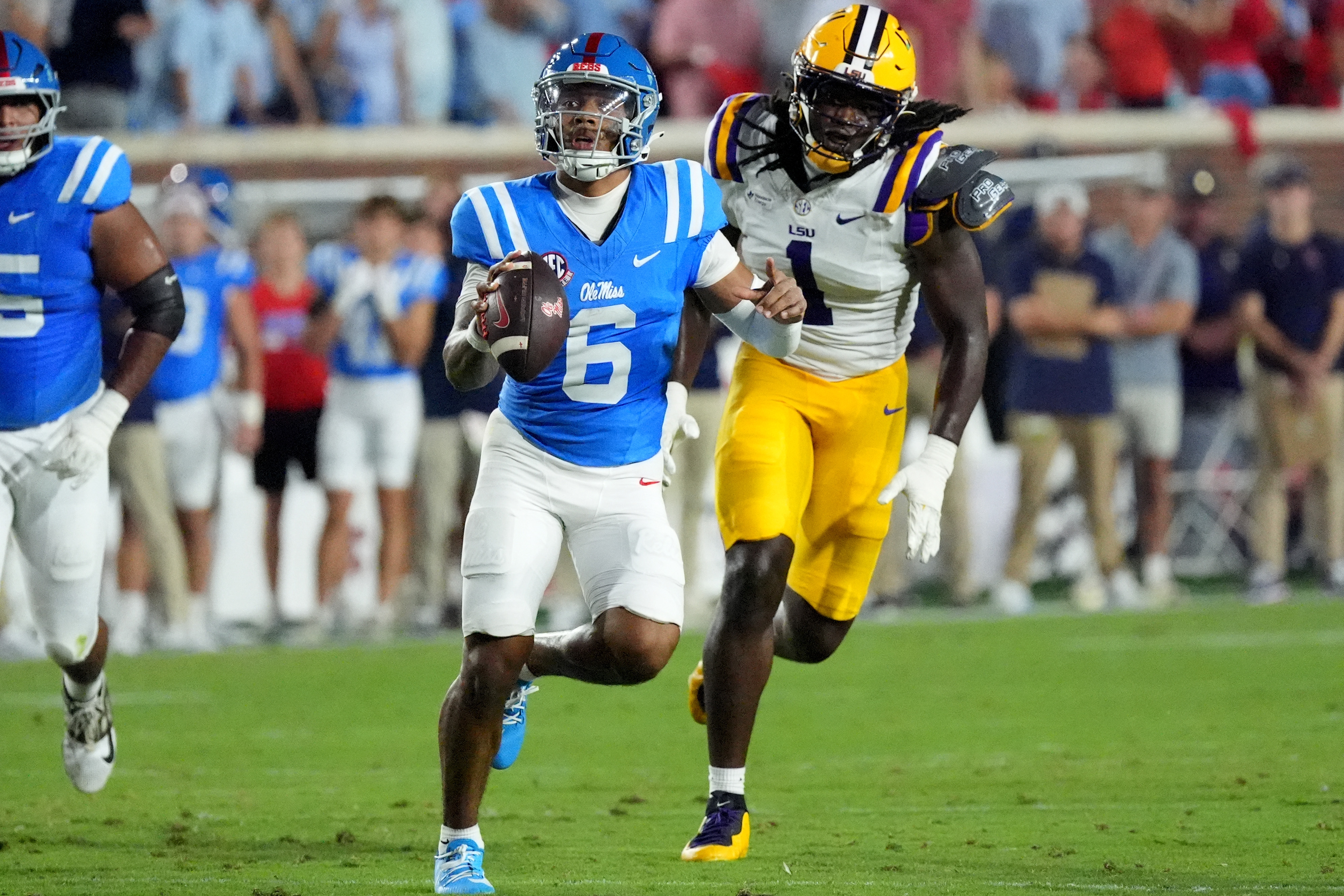 Mississippi quarterback Trinidad Chambliss (6) is pursued by LSU defensive end Princewill Umanmielen (1) during the first half of an NCAA college football game in Oxford, Miss., Saturday, Sept. 19, 2026. 