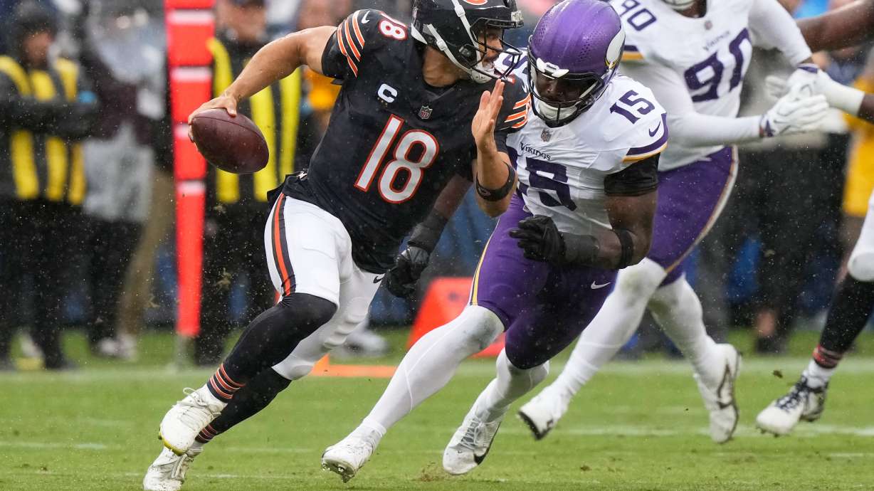Chicago Bears quarterback Caleb Williams (18) scrambles as Minnesota Vikings outside linebacker Dallas Turner (15) defends during the first half of an NFL football game in Chicago, Sunday, Sept. 20, 2026.