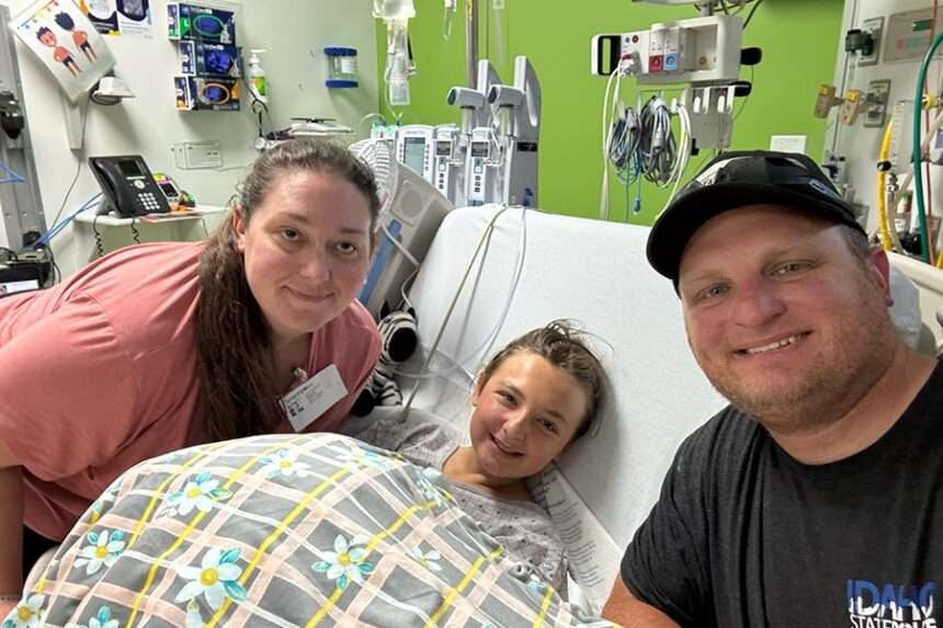 Chloe Hanish poses for a picture with her parents at the hospital.