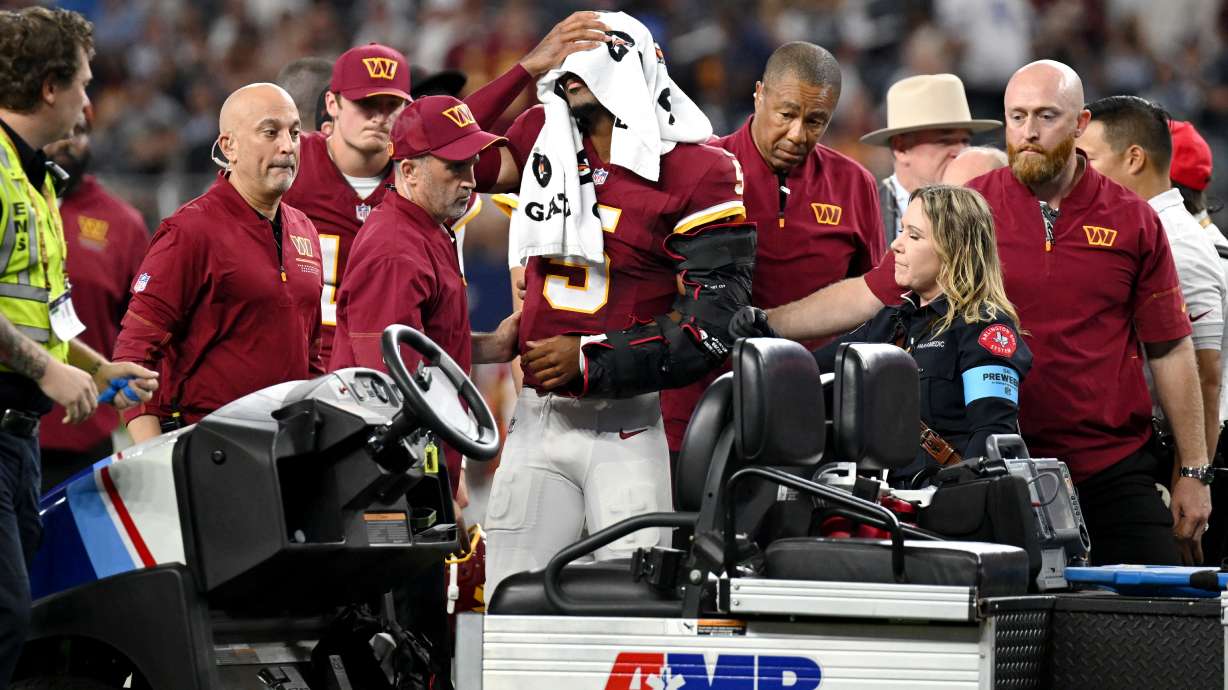 Trainers attend to Washington Commanders quarterback Jayden Daniels (5) after an apparent injury in the first half against the Dallas Cowboys during an NFL football game in Arlington, Texas, Sunday, Sept. 20, 2026.