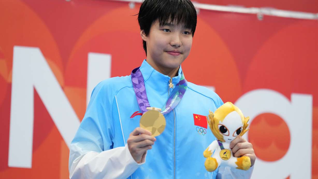 Gold medalist Yu Zidi of China poses on the podium after the women's 200-meter individual medley final in swimming at the Asian Games in Tokyo, Japan, Monday, Sept. 21, 2026.