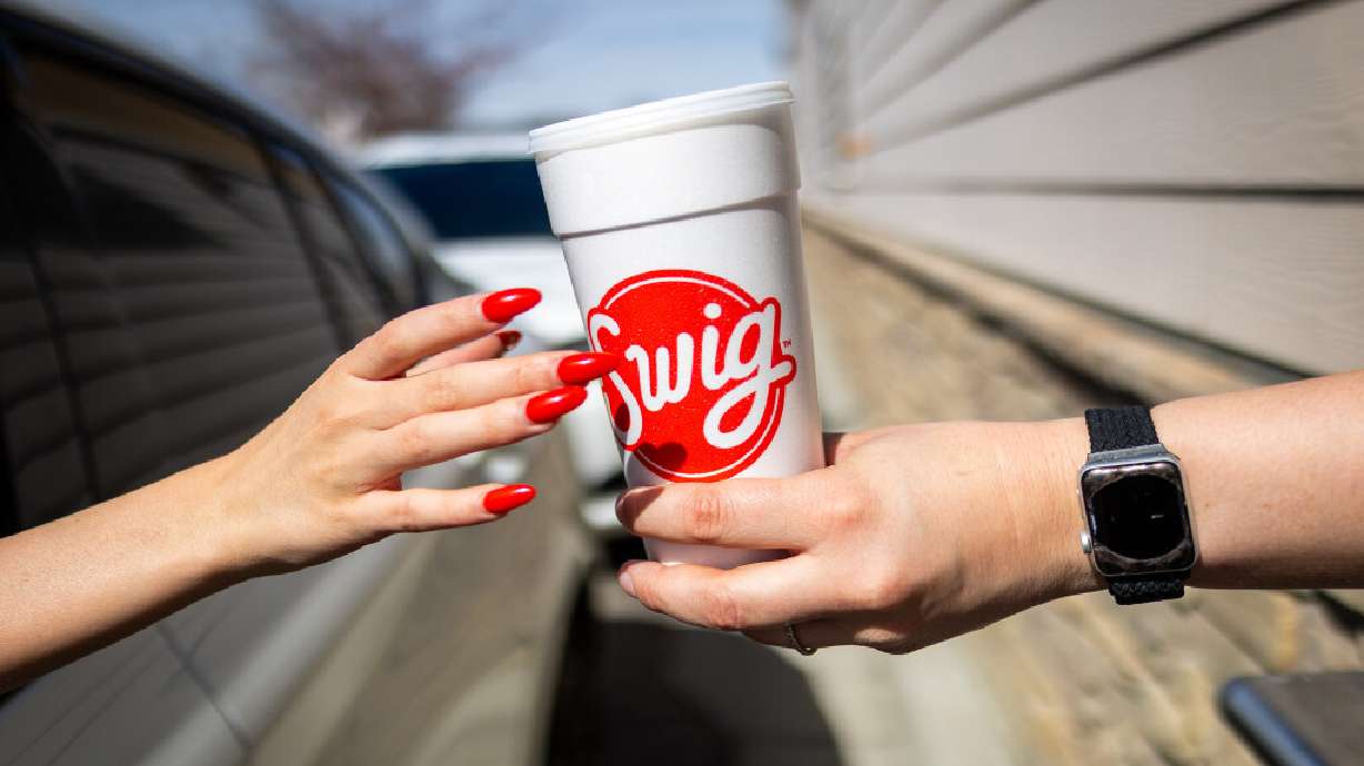 A customer grabs their drink in the drive-thru at a Swig in Draper on March 12. Through Oct. 10, all Swig locations are participating in the annual "Save the Cups" campaign, which raises money to help women struggling with the financial burden of breast cancer.