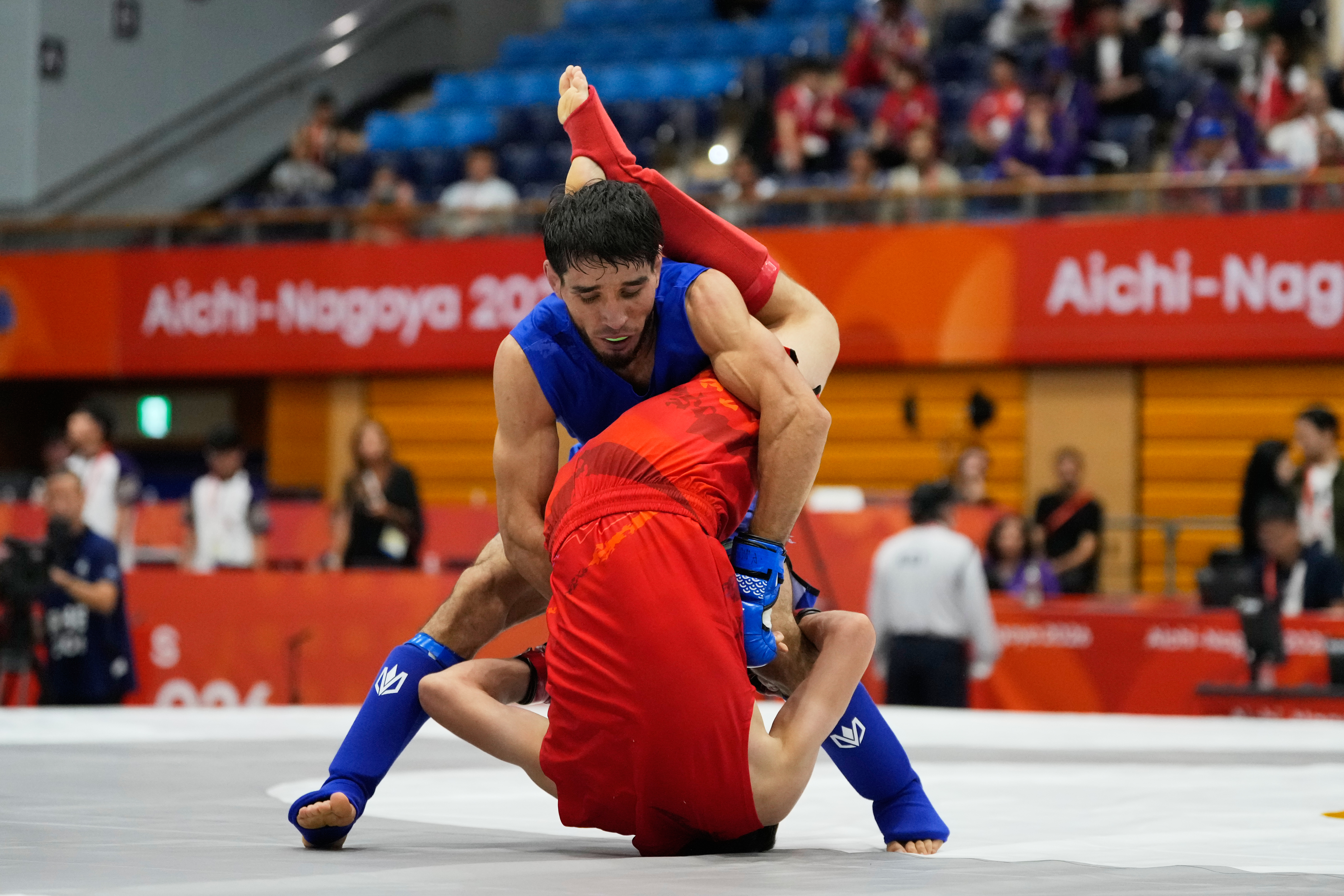 Firdaus Atamuratov of Uzbekistan, bottom, competes with Mirzobek Umarov of Tajikistan during their men's modern 60kg mixed martial arts final at the Asian Games in Nagoya, Japan, Tuesday, Sept. 22, 2026. 