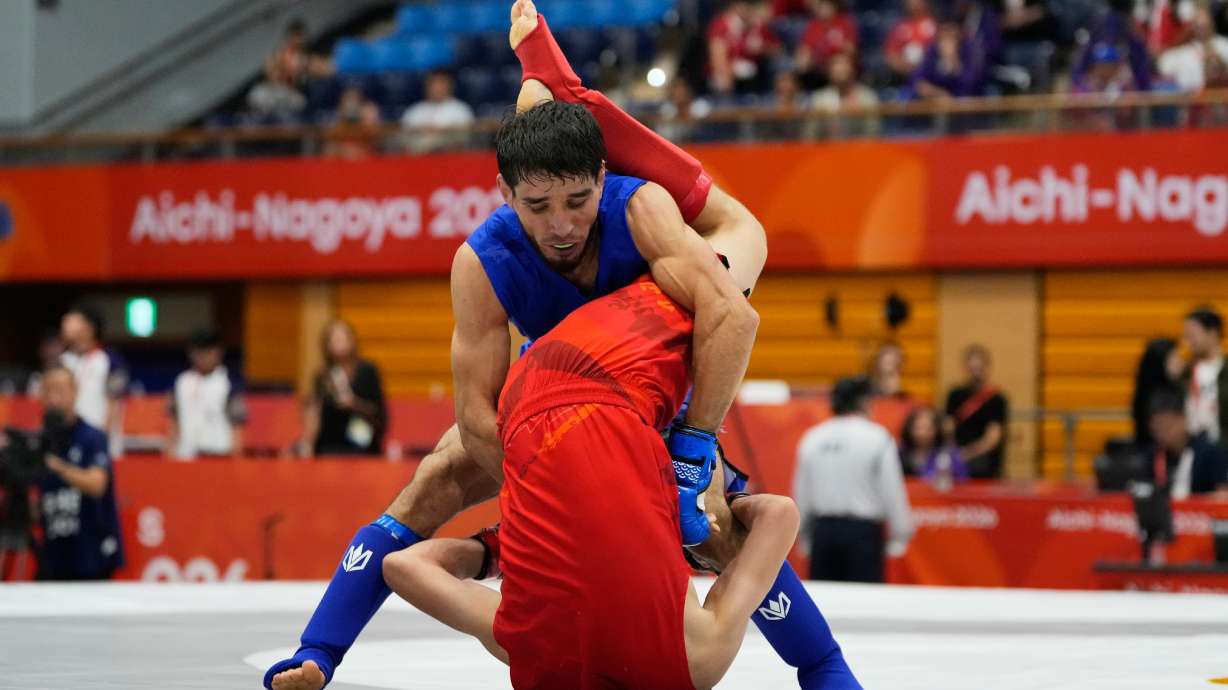 Firdaus Atamuratov of Uzbekistan, bottom, competes with Mirzobek Umarov of Tajikistan during their men's modern 60kg mixed martial arts final at the Asian Games in Nagoya, Japan, Tuesday, Sept. 22, 2026.