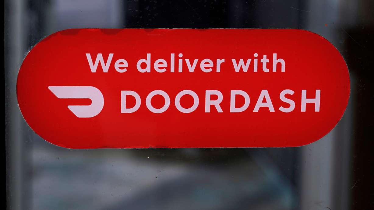A DoorDash sign is posted on a door, Feb. 27, 2023, in Methuen, Mass. DoorDash will pay $131.5 million to settle claims that it underpaid delivery workers in New York City, Mayor Zohran Mamdani announced Tuesday.