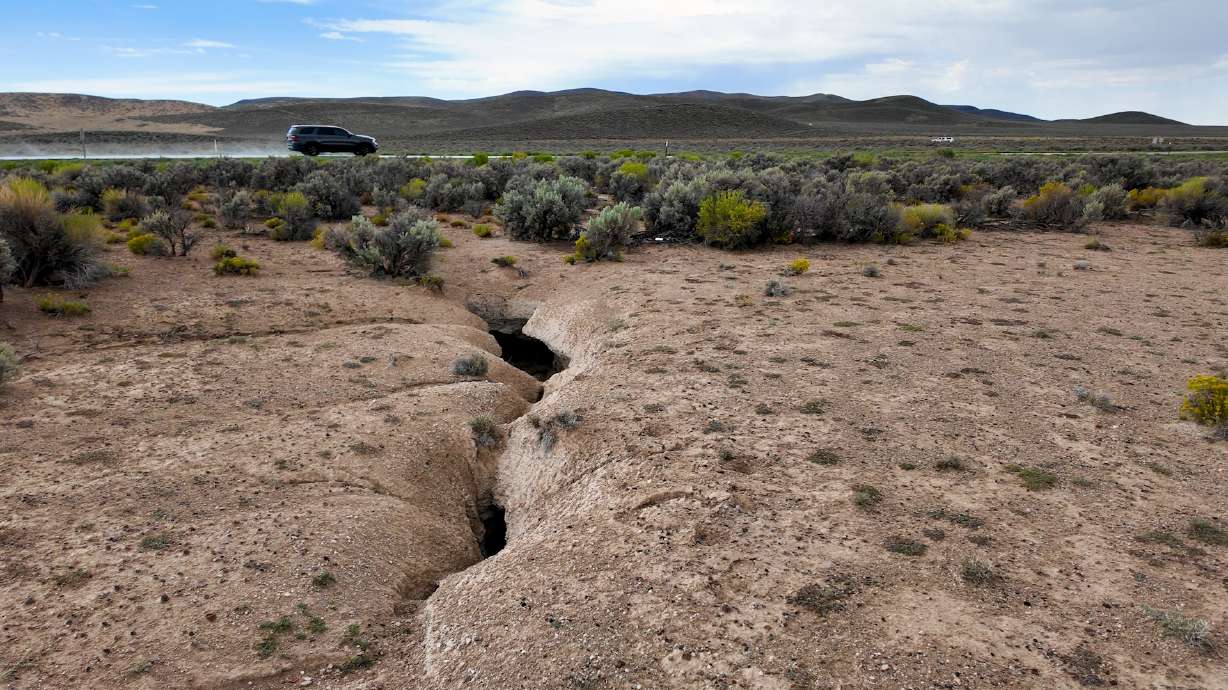 A fissure in the Escalante Valley reaches up to the nearby roadway, where past repairs have been made. Geologists are studying what they call fissures in the earth that are popping up as a result of decades of aquifer use and depletion.