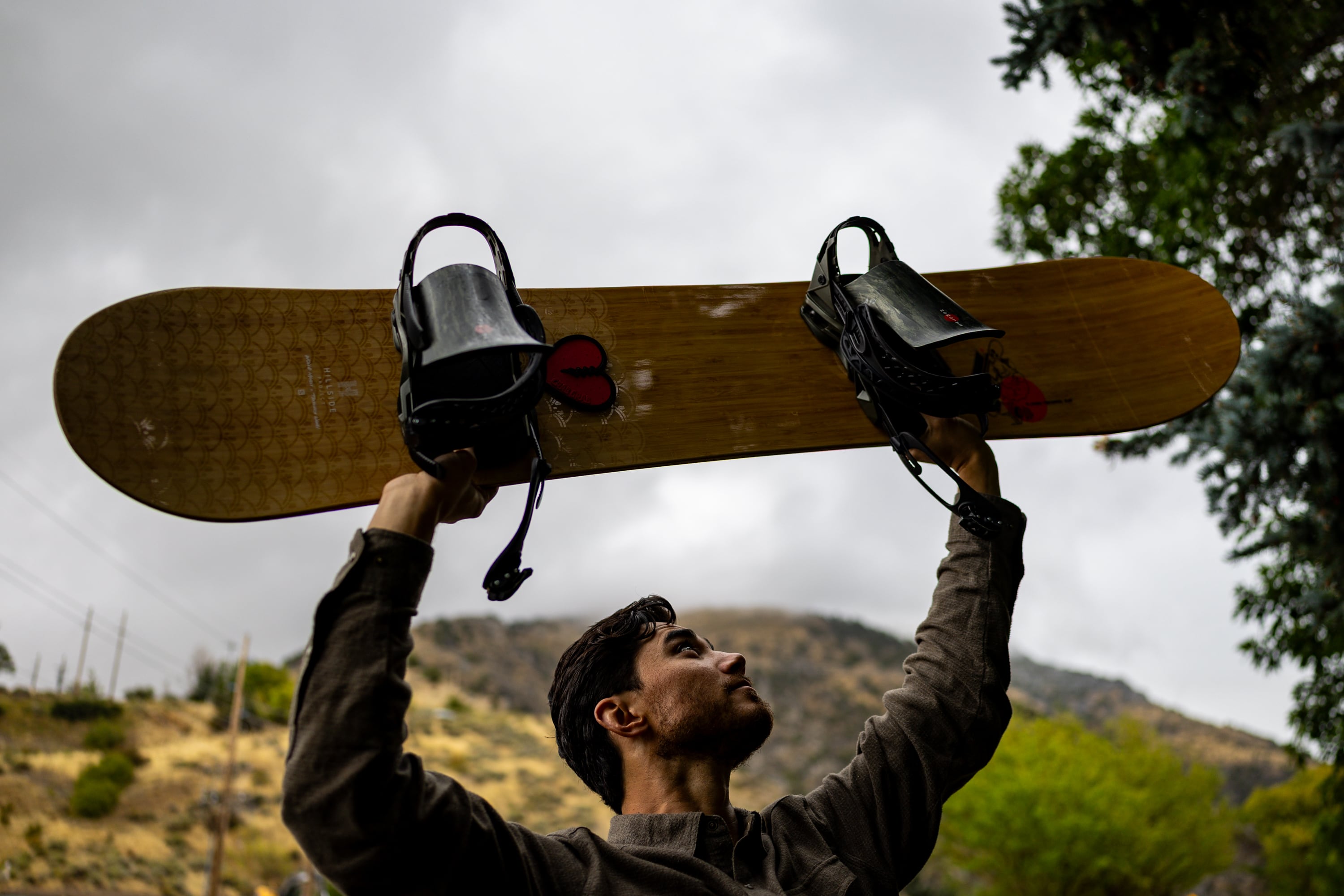 Clint Richins, who is looking at the feasibility of building a publicly owned ski resort, poses with his snowboard at River Hollow Park in Logan Canyon in Logan on Sept. 18.