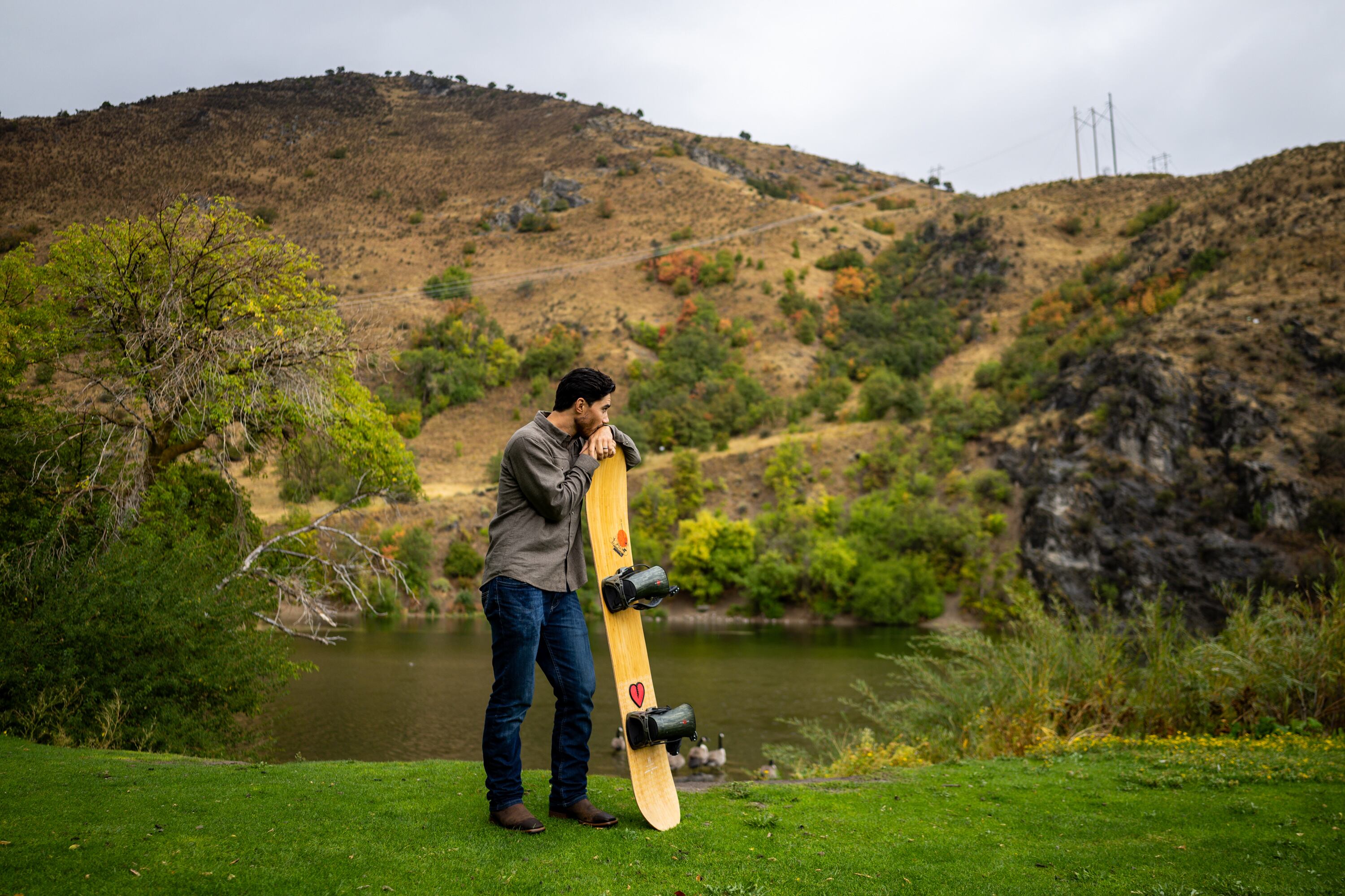 Clint Richins, who is looking at the feasibility of building a publicly owned ski resort, poses with his snowboard at River Hollow Park in Logan Canyon in Logan on Sept. 18.