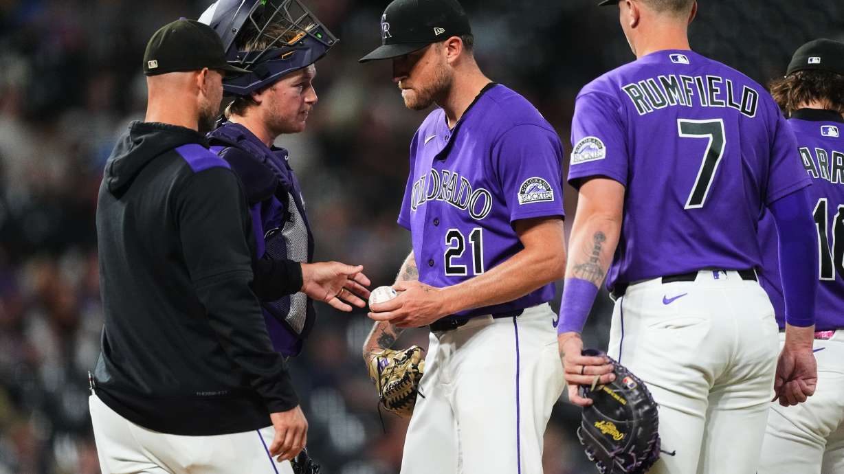 Colorado Rockies starting pitcher Kyle Freeland, center, hands the ball as he is pulled from the mound to manager Warren Schaeffer, front left, as catcher Hunter Goodman, back left, and first baseman TJ Rumfield look on in the fourth inning of a baseball game against the Arizona Diamondbacks Tuesday, Sept. 22, 2026, in Denver.