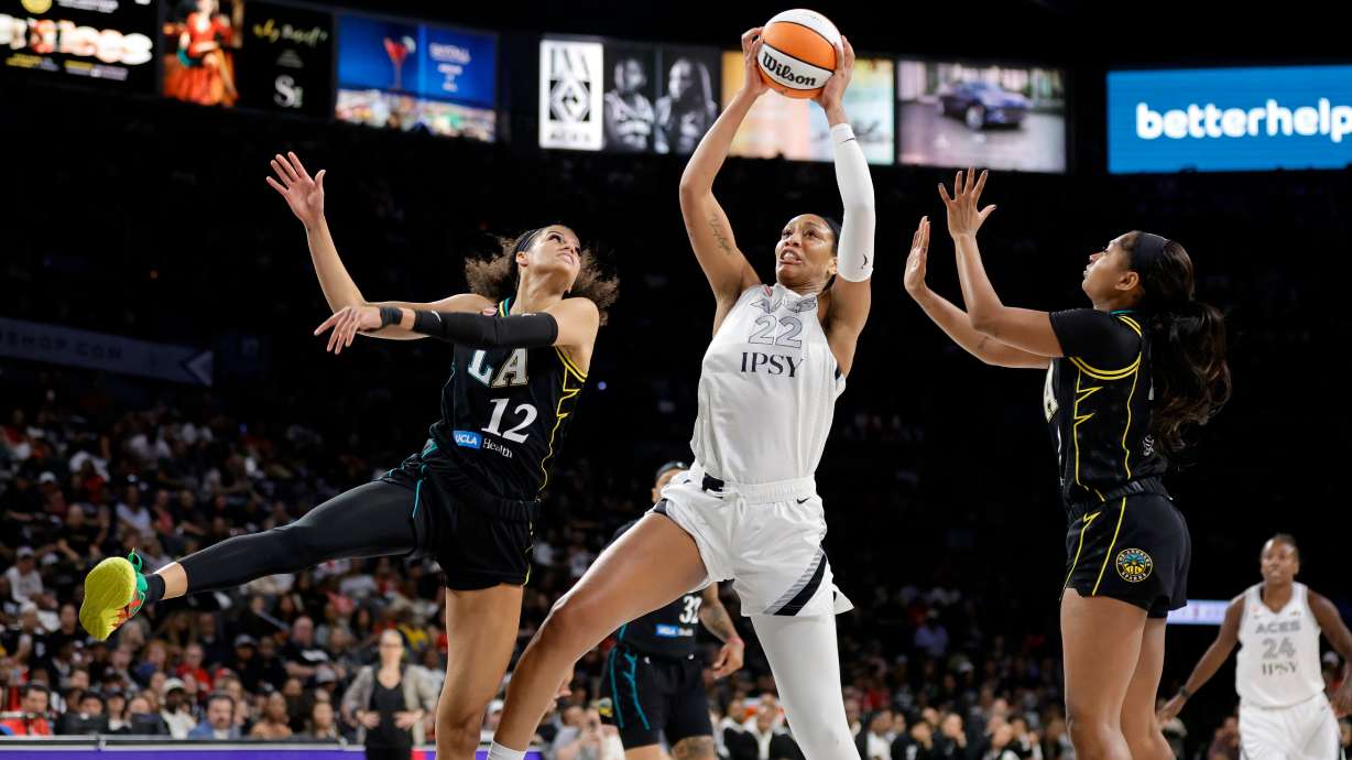 Las Vegas Aces center A'ja Wilson (22) makes a rebound between Los Angeles Sparks guards Rae Burrell (12) and Chance Gray during the first half of an WNBA basketball game Tuesday, Sept. 22, 2026, in Las Vegas.