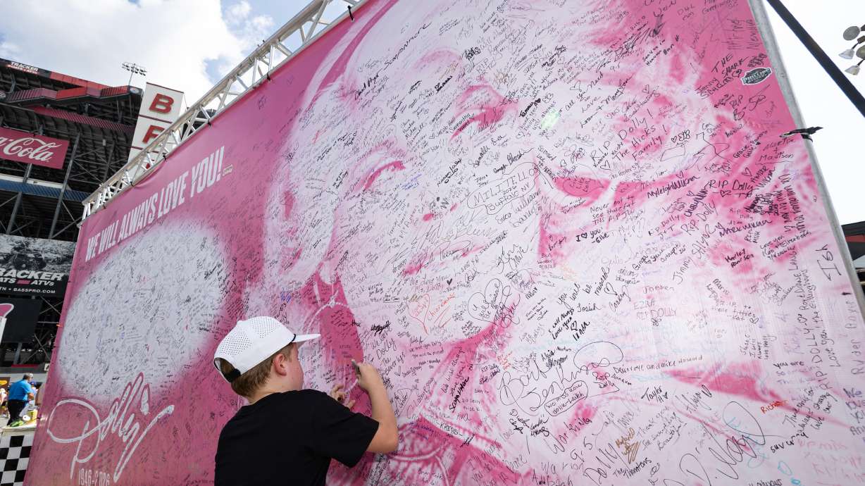Henry Bailey, 7, from Kentucky, signs a tribute sign to the late Dolly Parton before a NASCAR Cup Series race Saturday in Bristol, Tenn. Parton's estate is asking to keep her nephew, Bryan Seaver, away from their business and employees.