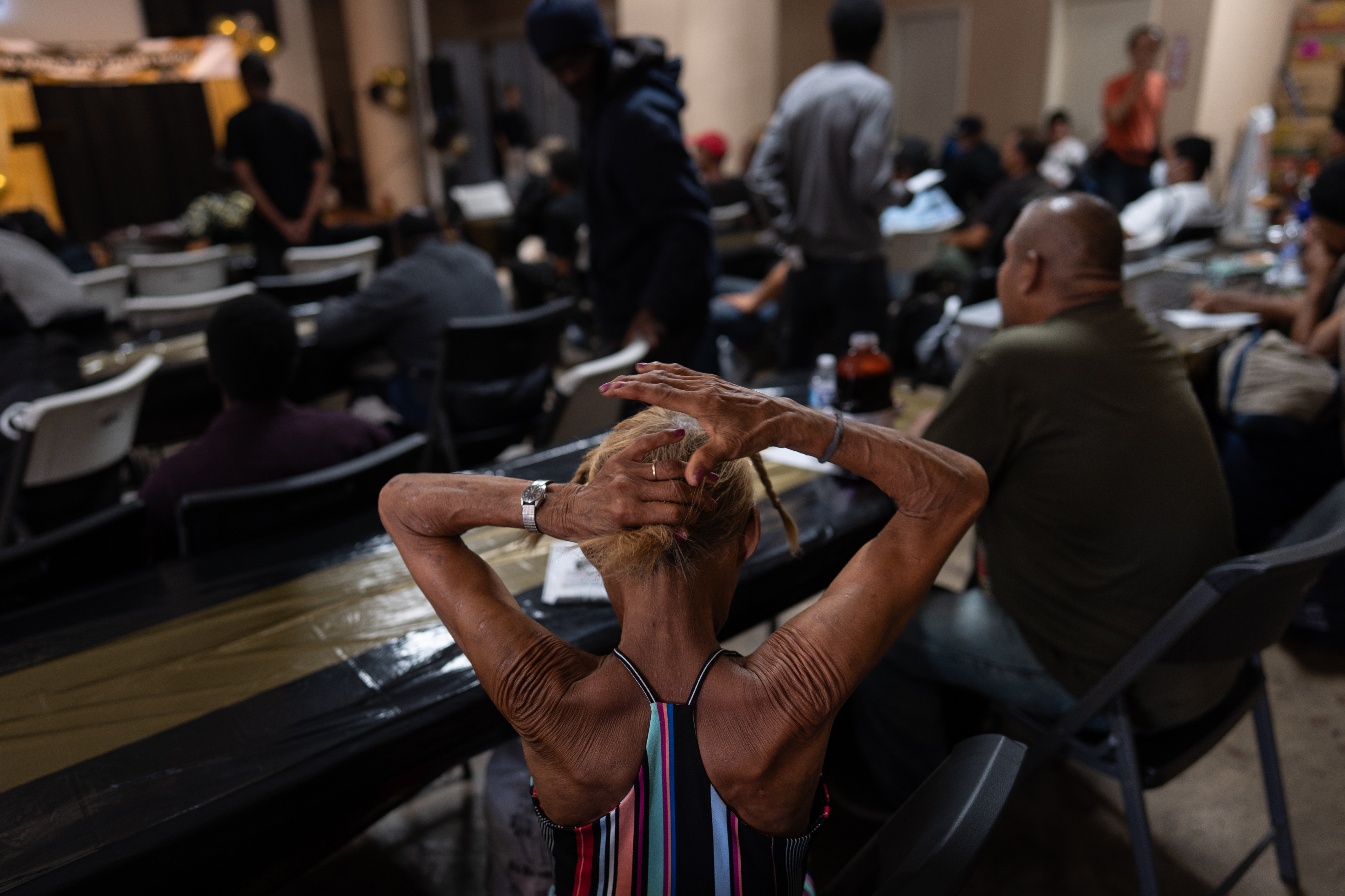 A woman in the audience fixes her hair before the start of Skid Row's inaugural talent show in downtown Los Angeles, Saturday.