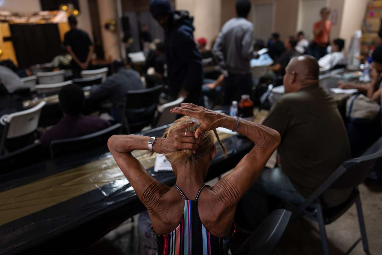 A woman in the audience fixes her hair before the start of Skid Row's inaugural talent show in downtown Los Angeles, Saturday.