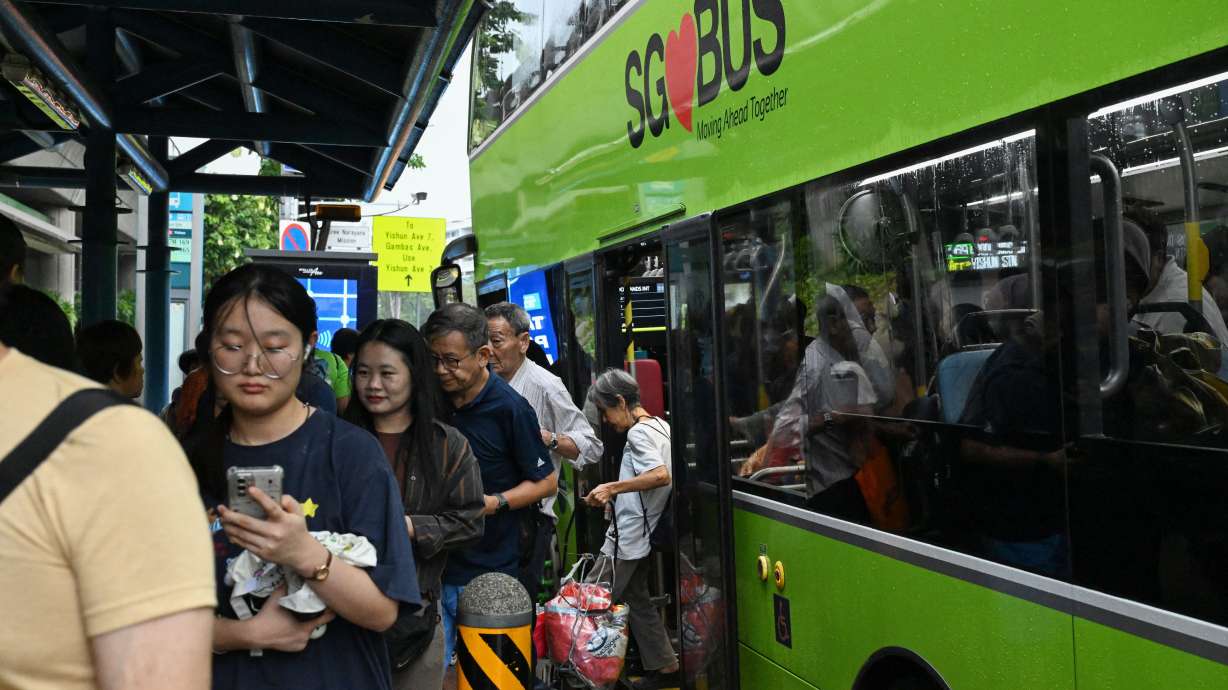 People exit a public bus in Singapore on Sept. 21.