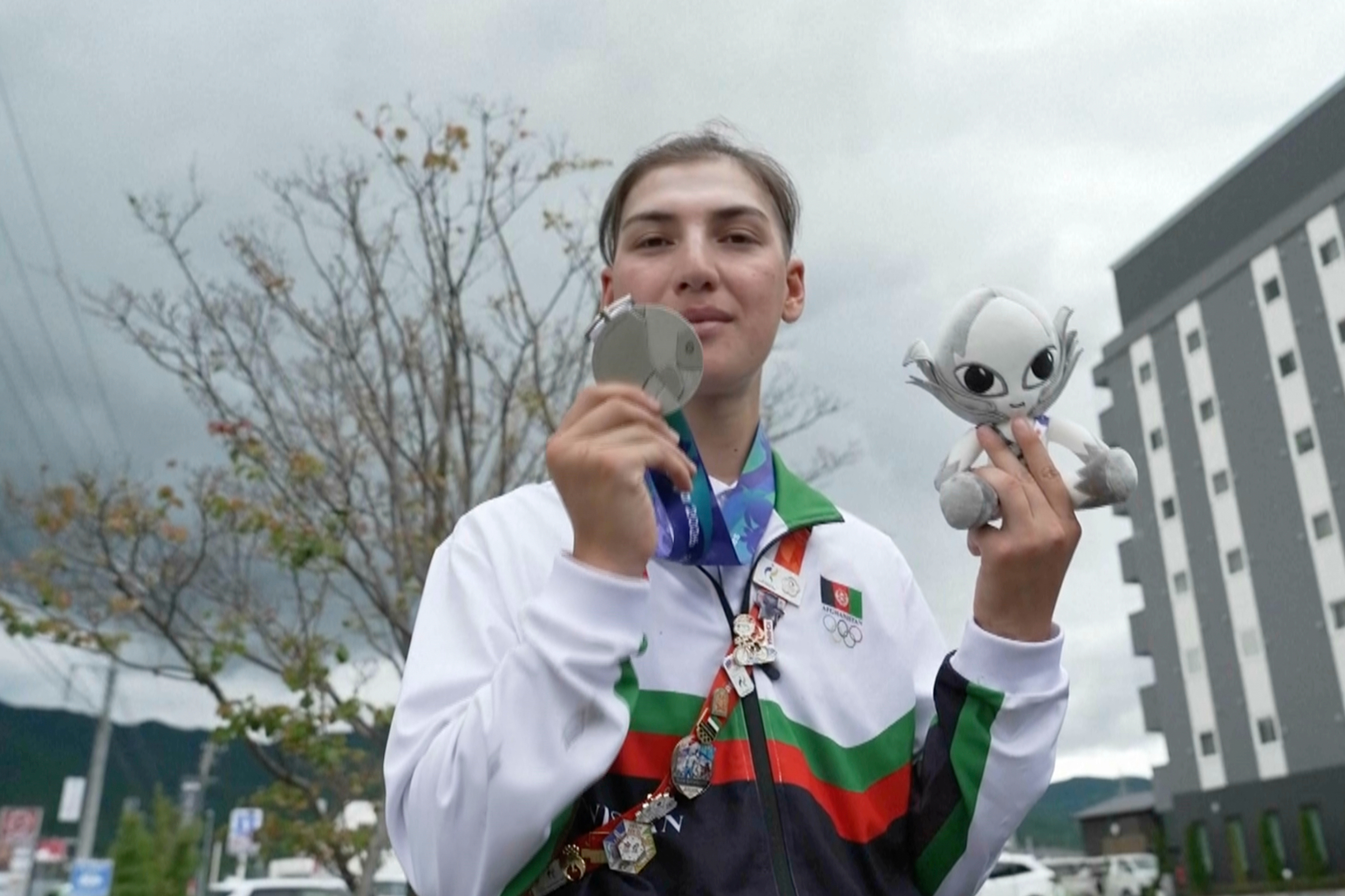 In this image made from video, Afghanistan's Fariba Hashim displays the silver medal she won for Women's Road Race, in Shinshiro, Japan, Wednesday, Sept. 23, 2026. 
