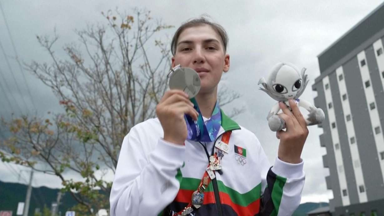 In this image made from video, Afghanistan's Fariba Hashim displays the silver medal she won for Women's Road Race, in Shinshiro, Japan, Wednesday, Sept. 23, 2026.