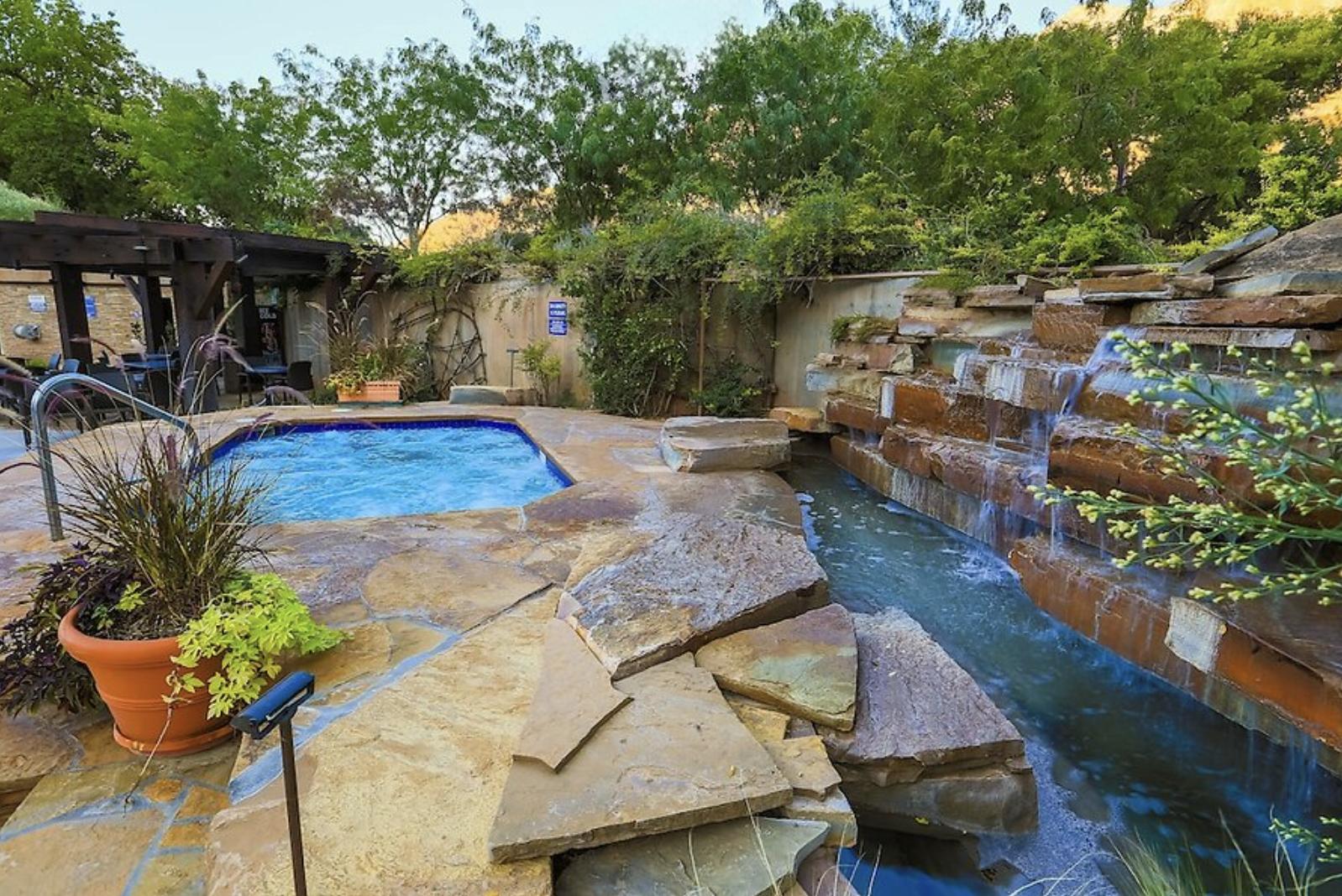 Outdoor hot tub and waterfall.