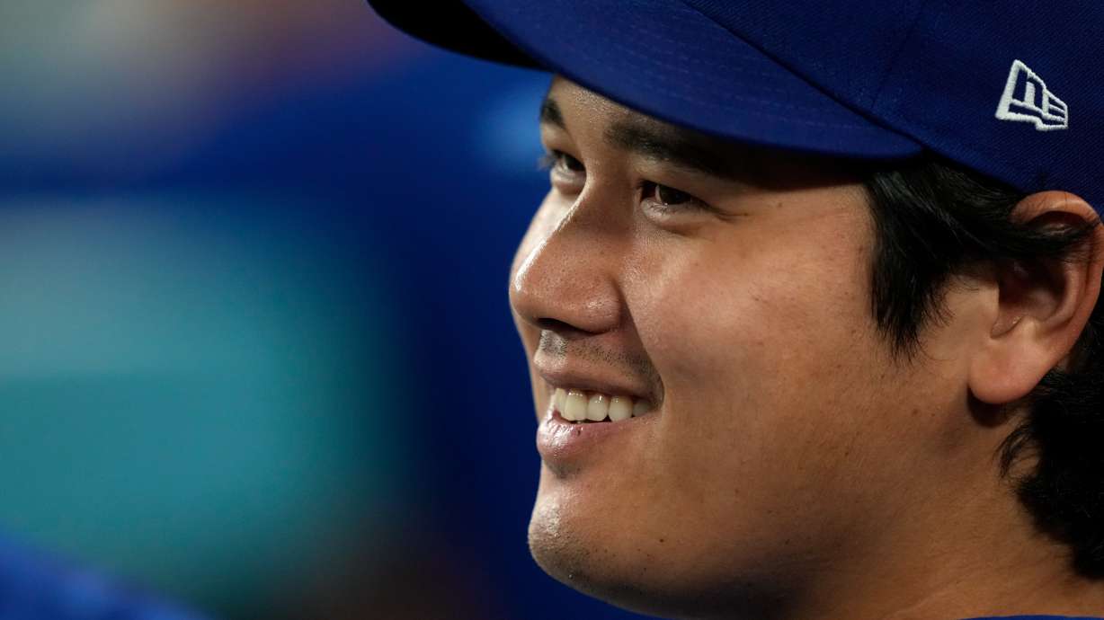 Los Angeles Dodgers' Shohei Ohtani smiles as he sits in the dugout during the eighth inning of a baseball game against the San Diego Padres, Tuesday, Sept. 22, 2026, in Los Angeles.