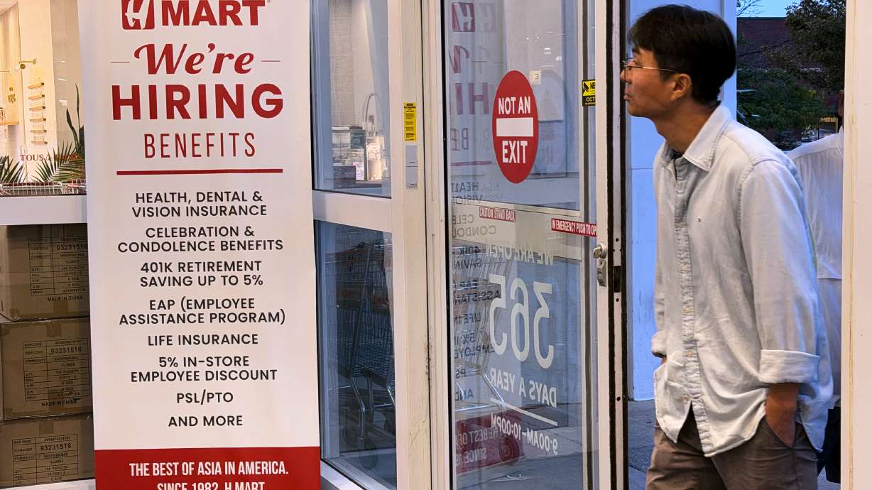 A hiring sign is displayed at a grocery store, in Schaumburg, Ill., Sept. 16. Fewer people applied for unemployment benefits last week, as jobless claims remain at historically low levels and most Americans enjoy job security.