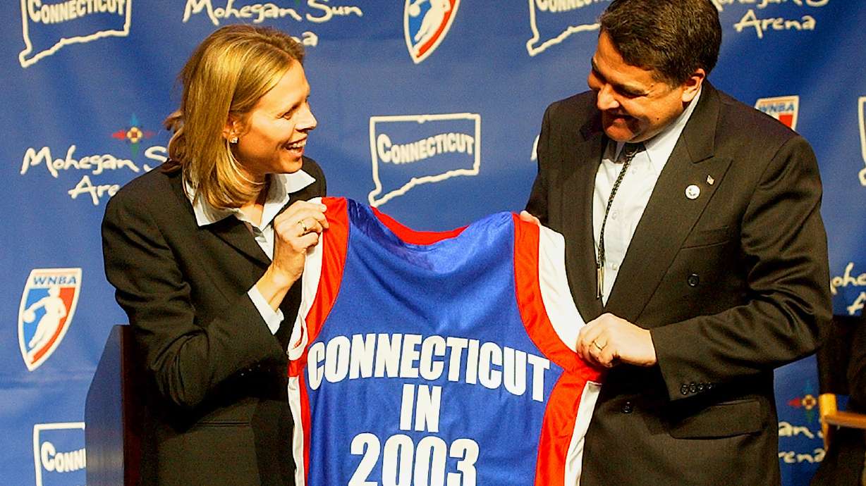 FILE - WNBA League President Val Ackerman, left, and Mohegan Tribe Tribal Chairman Mark Brown hold a basketball shirt of the type that will be worn by the WNBA team Connecticut Sun during a news conference Tuesday, Jan. 28, 2003, at the Mohegan Sun Arena in Uncasville, Conn.