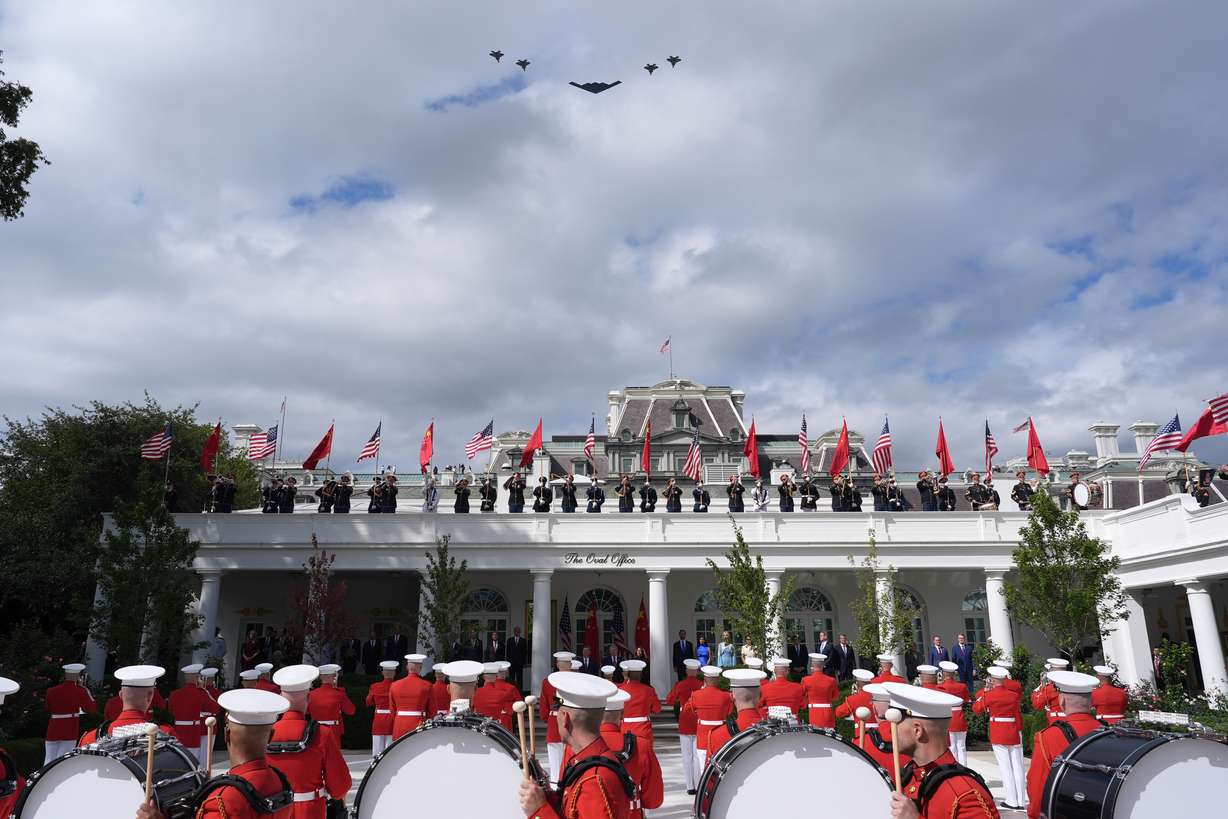 A military flyover is pictured as President Donald Trump, first lady Melania Trump, China's President Xi Jinping and his wife Peng Liyuan watch a military review in the Rose Garden of the White House, Thursday, in Washington. The lavish welcome ceremony was the kickoff to a summit between Xi and Trump.