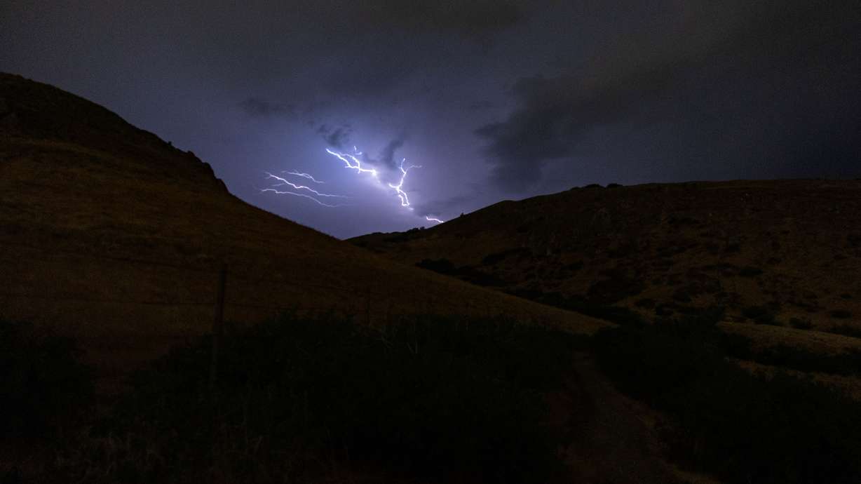 Lightning strikes above Ensign Peak during a thunderstorm in Salt Lake City on July 21. Dashcam footage captured the moment lightning nearly struck a box truck driving on I-84 in Utah.