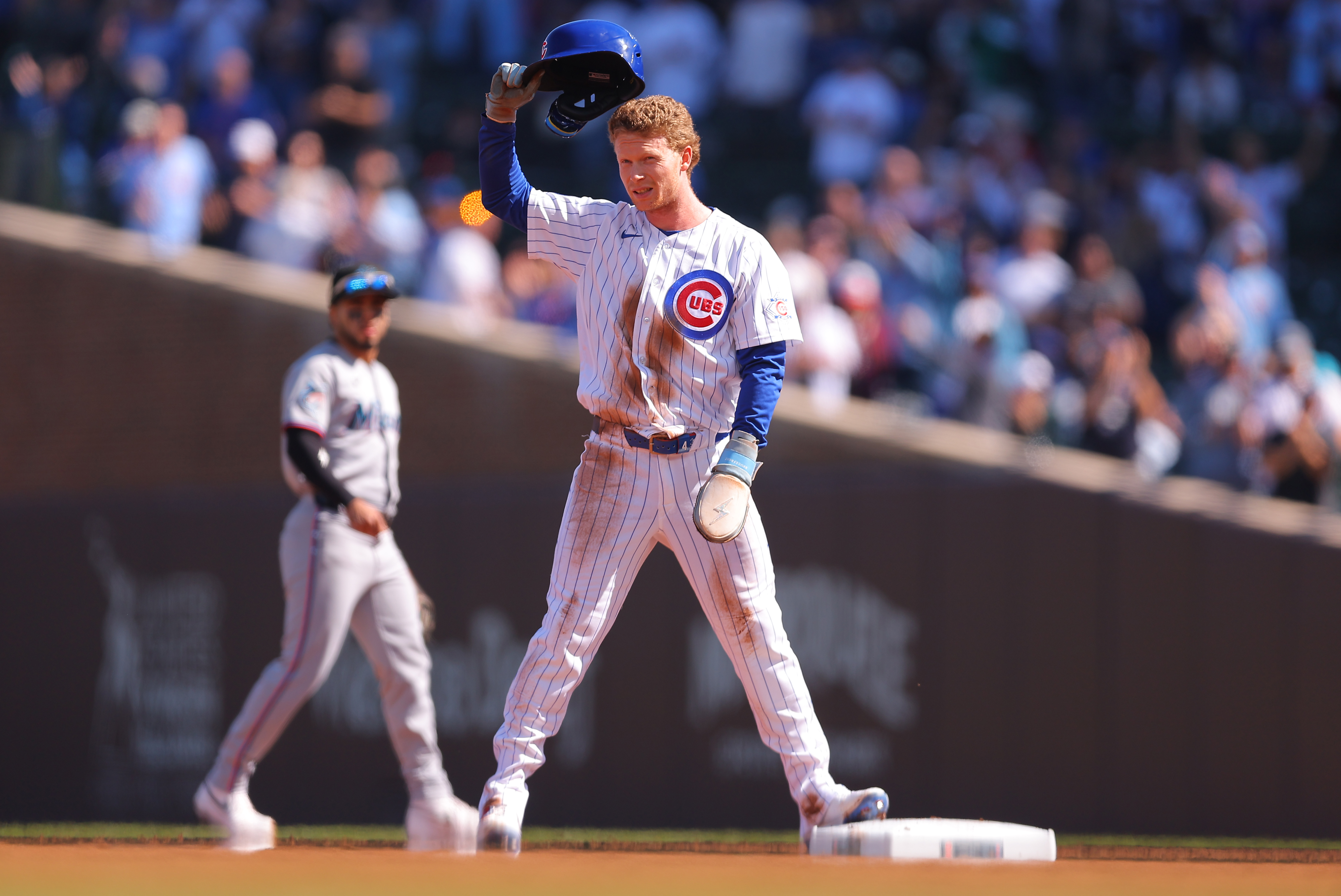 Chicago Cubs' Pete Crow-Armstrong raises his helmet to the crowd after stealing second base for his 40th steal of the season during the first inning of a baseball game against the Miami Marlins, Thursday , Sept. 24, 2026, in Chicago. 