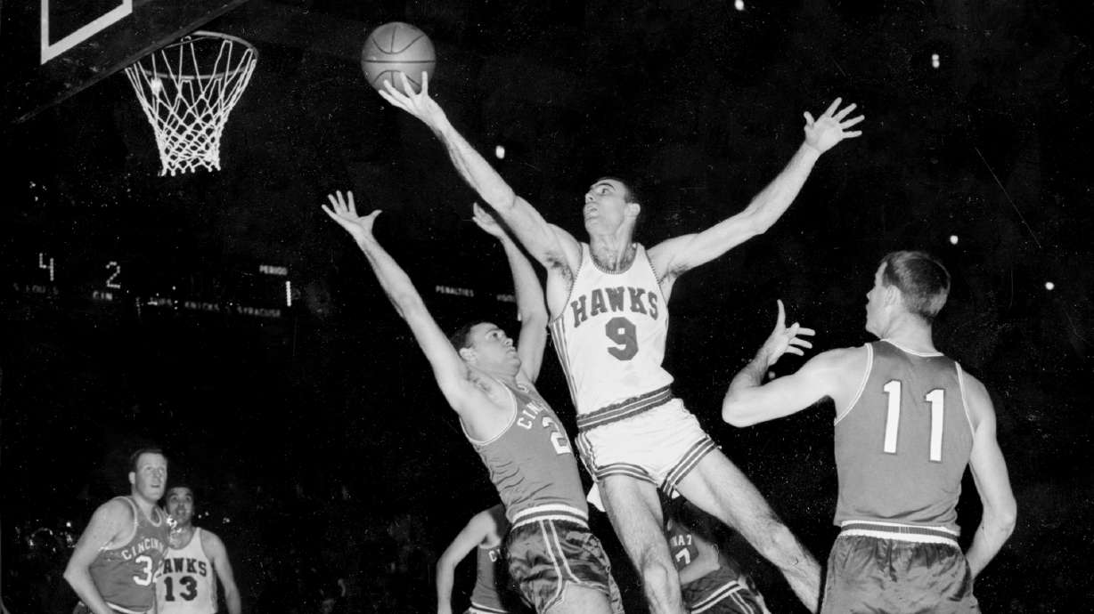 FILE - FILE - In this Dec. 10, 1957, file photo, Bob Pettit, of the St. Louis Hawks, leaps to make a one-handed shot but fails to connect for a score in the first quarter of an NBA basketball game against the Cincinnati Royals at Madison Square Garden in New York City. Blocking Pettit is Dick Ricketts (24) of the Royals as Jim Paxson (11) watches play.