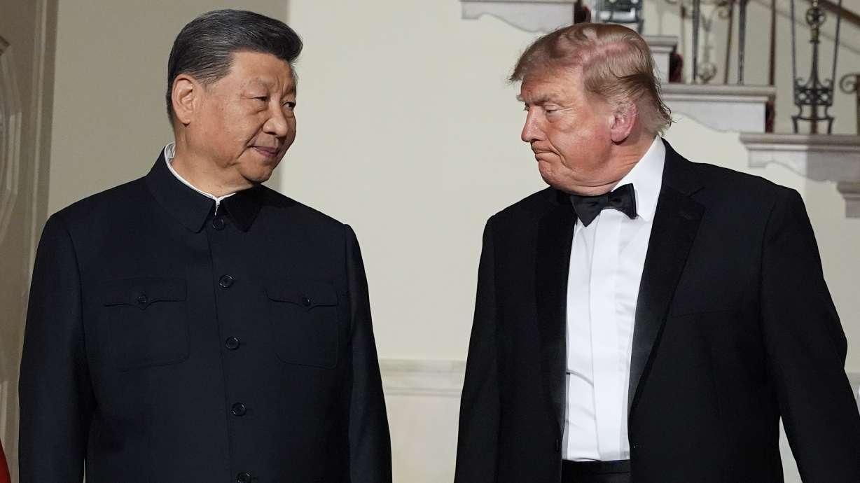 President Donald Trump and China's President Xi Jinping walk in the Grand Foyer of the White House during a state dinner, Thursday, in Washington. Trump and Xi will visit the National Archives on Friday.