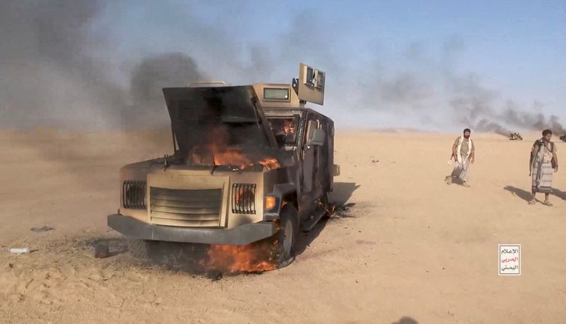 Iran-aligned Houthi fighters move next to a destroyed vehicle following what the source described as an attack on Saudi-backed forces in the location given by the source as al Jawf governorate, Yemen, in this screengrab taken from a video released by Houthi Military Media on Sep. 15.