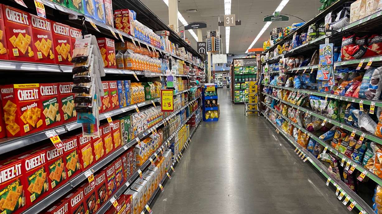 Boxes of crackers and bags of chips are pictured on the shelves of a local grocery store in Salt Lake City on April 11, 2022.