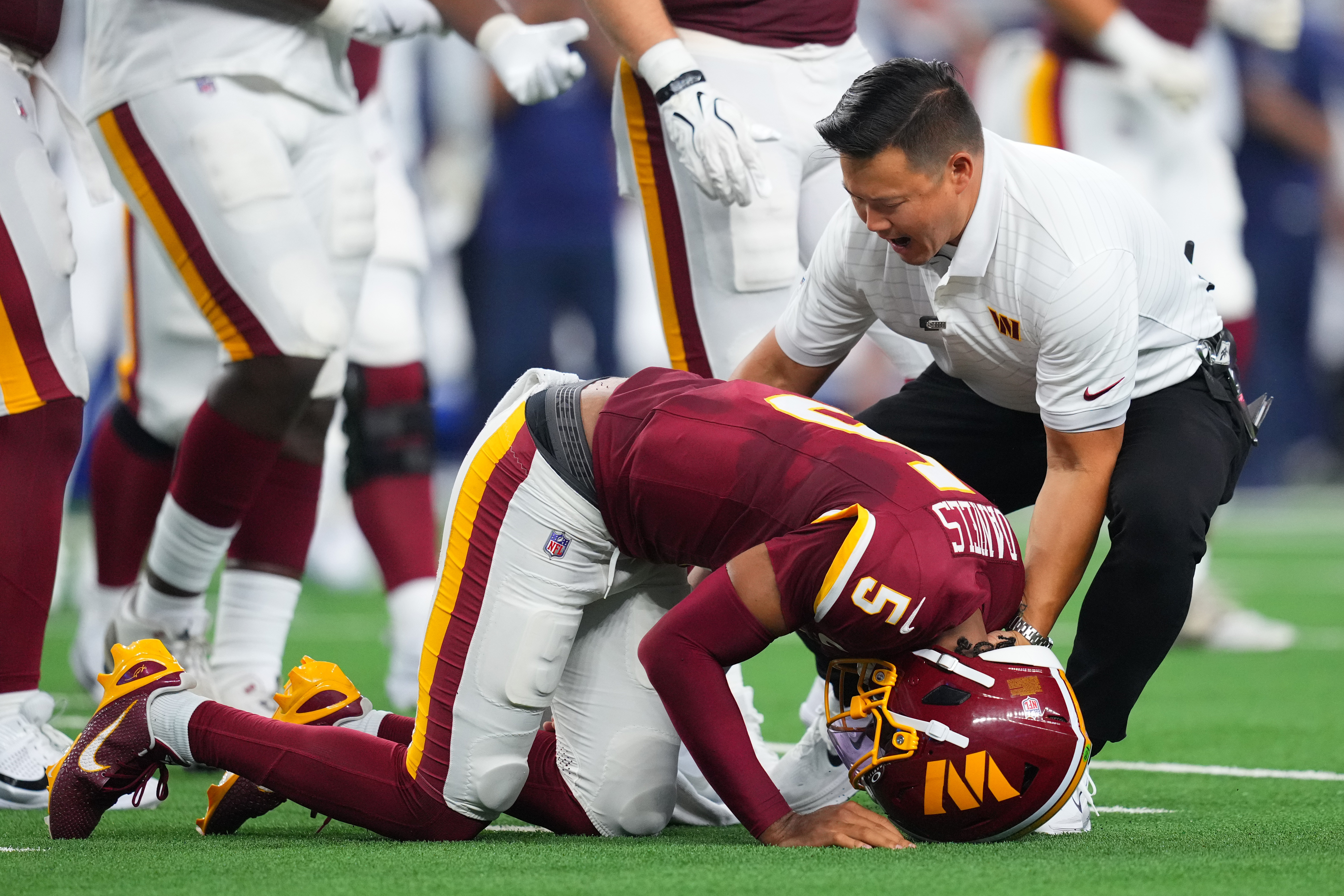 Washington Commanders quarterback Jayden Daniels (5) reacts after an apparent injury in the first half against the Dallas Cowboys during an NFL football game in Arlington, Texas, Sunday, Sept. 20, 2026. 