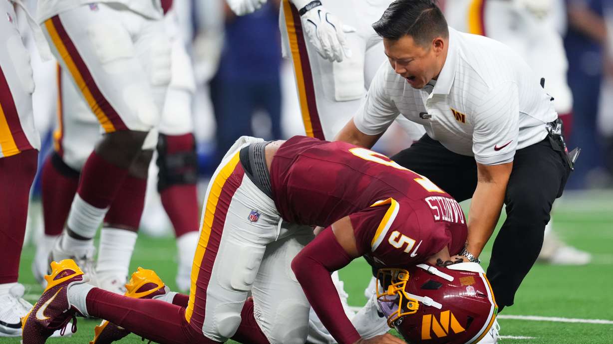 Washington Commanders quarterback Jayden Daniels (5) reacts after an apparent injury in the first half against the Dallas Cowboys during an NFL football game in Arlington, Texas, Sunday, Sept. 20, 2026.
