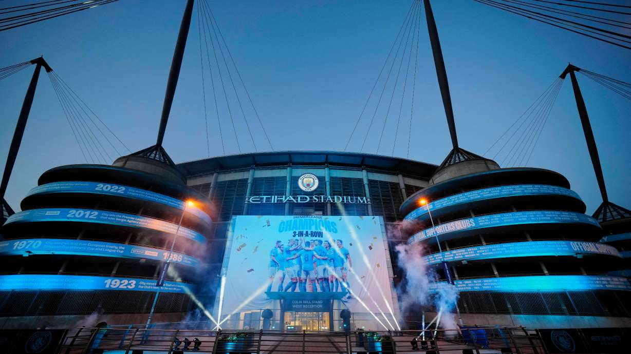 FILE - A banner celebrating their title win is illuminated outside Manchester City's Etihad stadium in Manchester, England, Saturday, May 20, 2023.