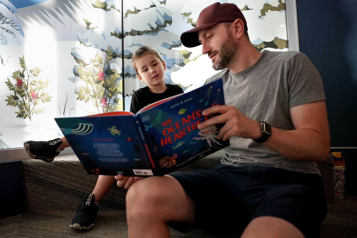 Four-year-old Aiden Robertson and his father, Anthony, read a book together on Dolly Parton Day at Glacier Hills Elementary School, Friday, in Sandy. The Dolly Parton Imagination Library is partnering with the Canyons Education Foundation to provide free books to every preschool child living in the Canyons boundaries.