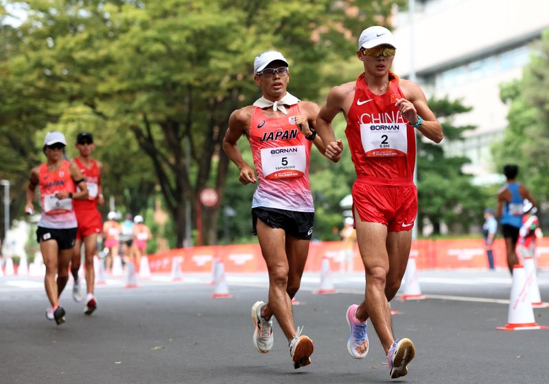Asian Games - Aichi-Nagoya 2026 - Race Walk - Aichi Prefectural Government Office and Nagoya City Hall Loop Course, Nagoya, Japan - September 23, 2026 Japan's Toshikazu Yamanishi and China's Shengji Shi in action during the men's half marathon race walk
