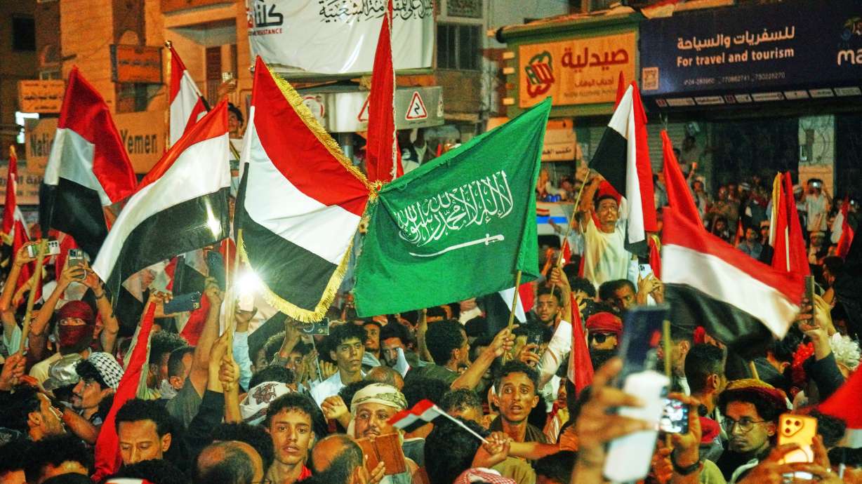 Yemenis wave national and Saudi flags as they celebrate the 64th anniversary of the Saturday Revolution in Taiz, Yemen, Friday.