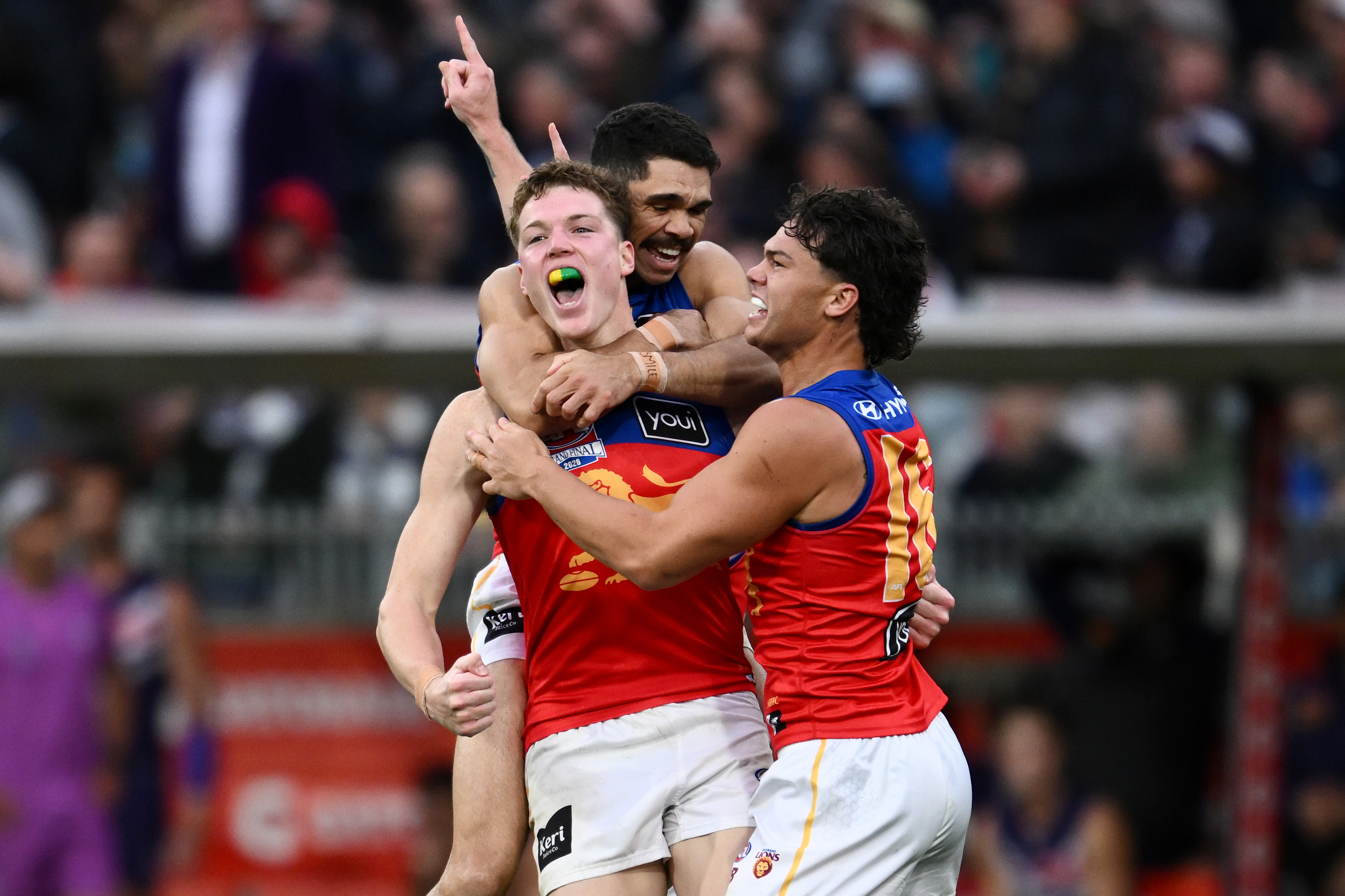 Brisbane Lions players Logan Morris, center, Charlie Cameron, rear, and Cam Rayner celebrate their win over the Fremantle Dockers in the Australian Football League grand final in Melbourne, Australia Saturday, Sept. 26, 2026. 