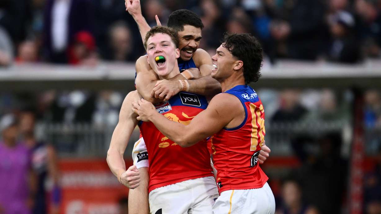 Brisbane Lions players Logan Morris, center, Charlie Cameron, rear, and Cam Rayner celebrate their win over the Fremantle Dockers in the Australian Football League grand final in Melbourne, Australia Saturday, Sept. 26, 2026.