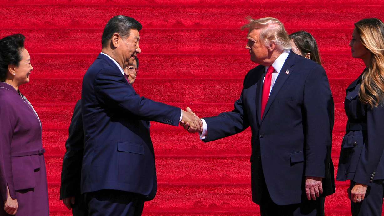 President Donald Trump, center right, shakes the hand of China's President Xi Jinping as first lady Melania Trump, right, and China's first lady Peng Liyuan, left, watch as they arrive at the National Archives Museum, Friday, in Washington.