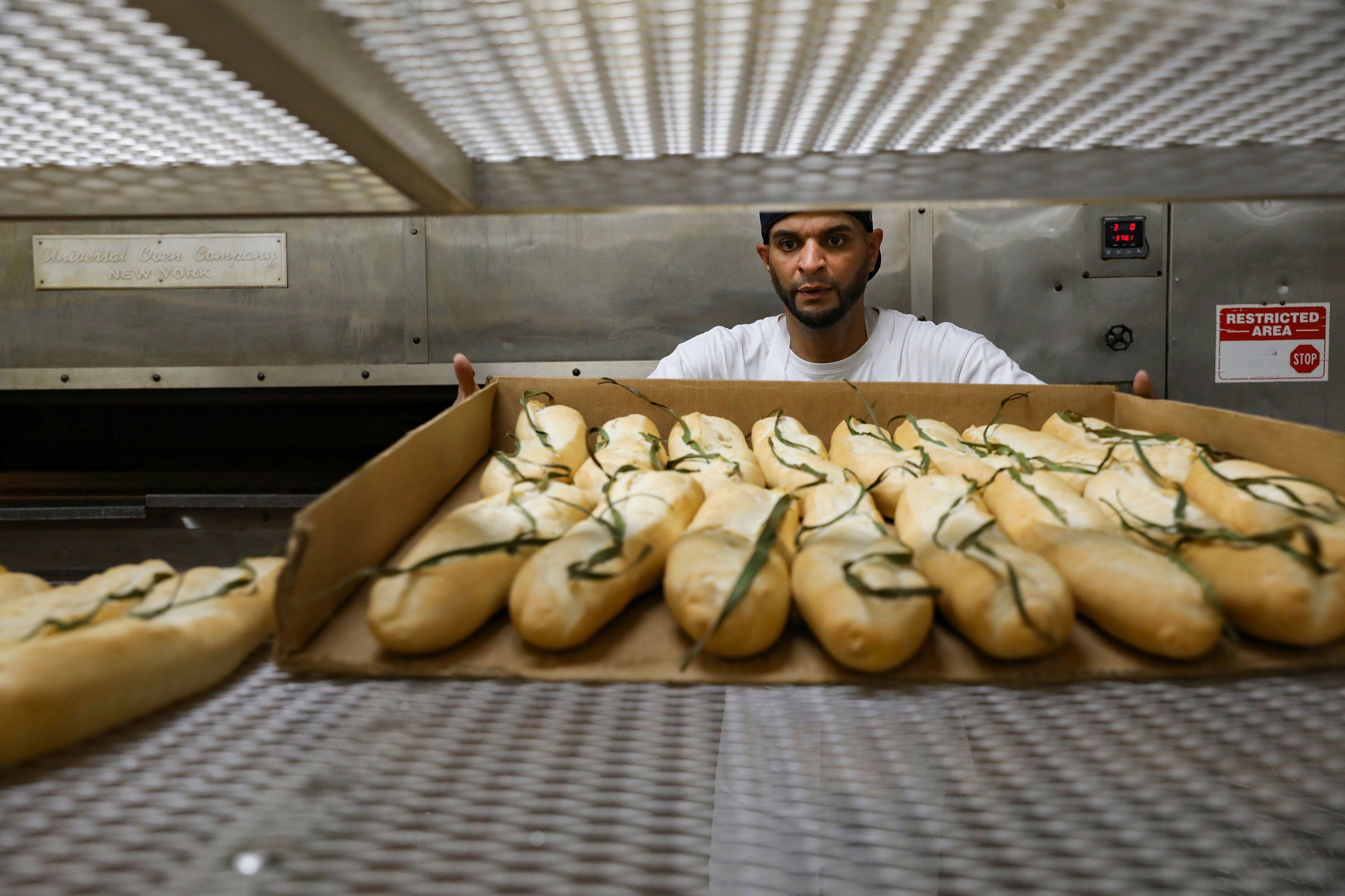 Orlando Rodrigues places loaves fresh out of the oven onto a rack at La Segunda Bakery in Ybor City.