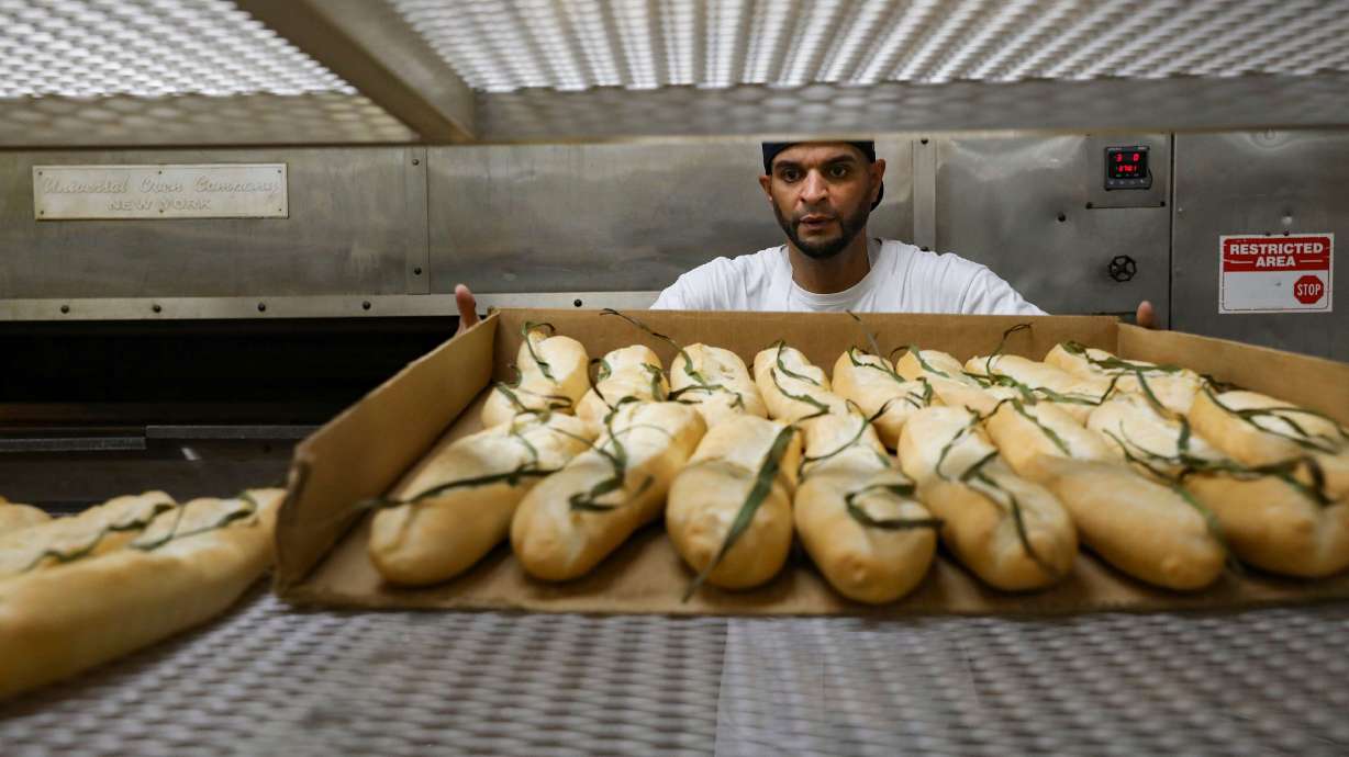 Orlando Rodrigues places loaves fresh out of the oven onto a rack at La Segunda Bakery in Ybor City.
