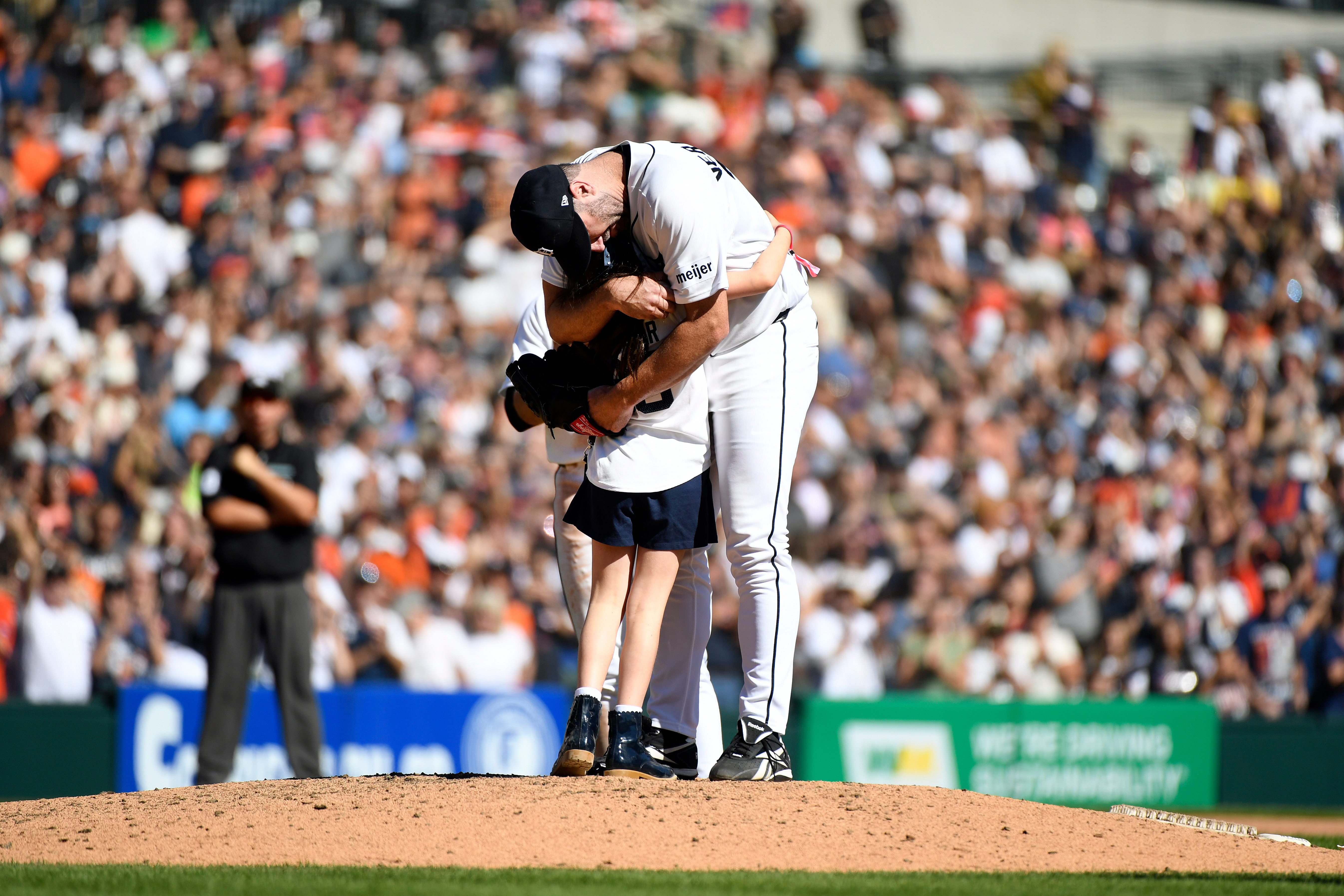 Genevieve Verlander, left, hugs her dad, Detroit Tigers starting pitcher Justin Verlander, during the sixth inning of a baseball game against the Pittsburgh Pirates, Saturday, Sept. 26, 2026, in Detroit. 