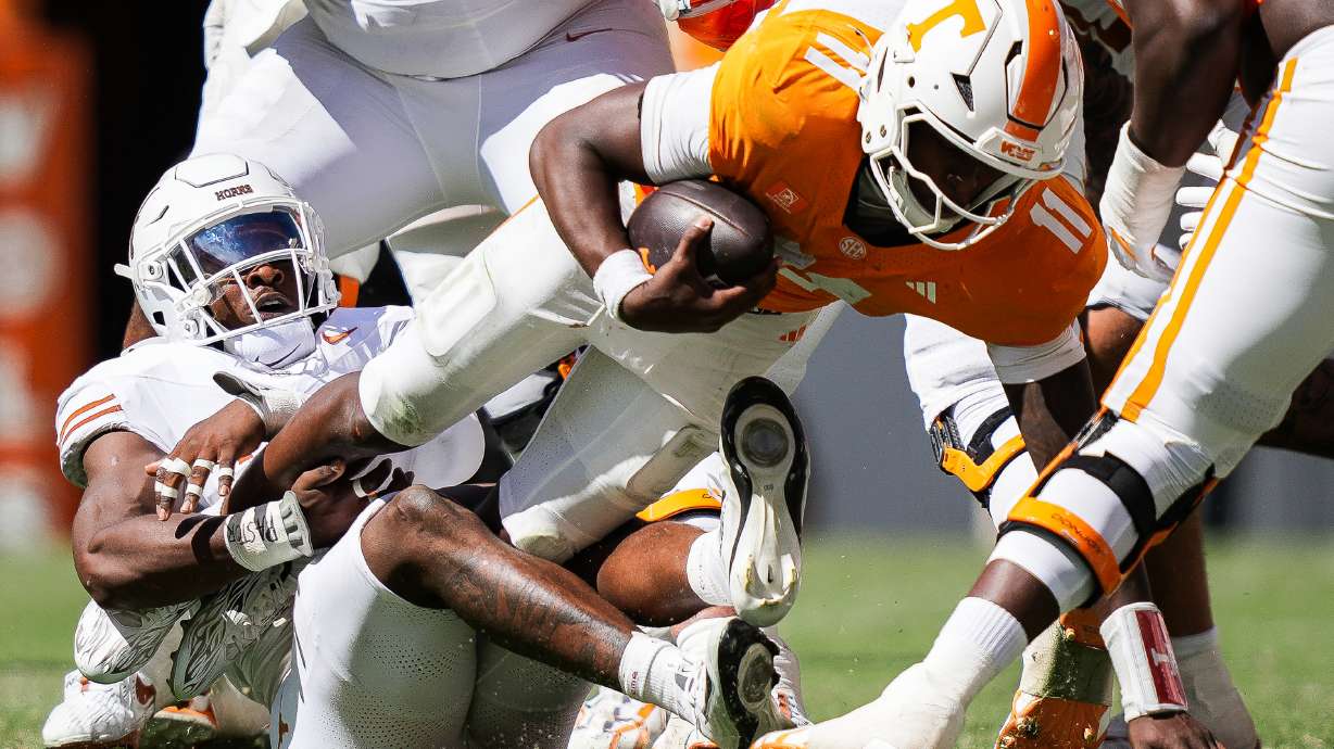 Texas defensive end Colin Simmons (1) brings down Tennessee quarterback Faizon Brandon (11) during the second half of an NCAA college football game in Knoxville, Tenn., Saturday, Sept. 26, 2026.