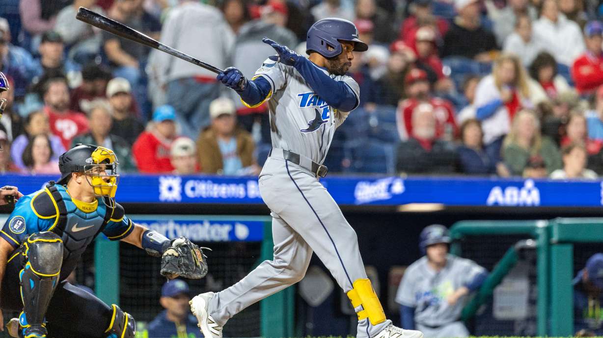 Tampa Bay Rays' Cedric Mullins, right, follows through on a single during the ninth inning of a baseball game against the Philadelphia Phillies, Friday, Sept. 25, 2026, in Philadelphia.