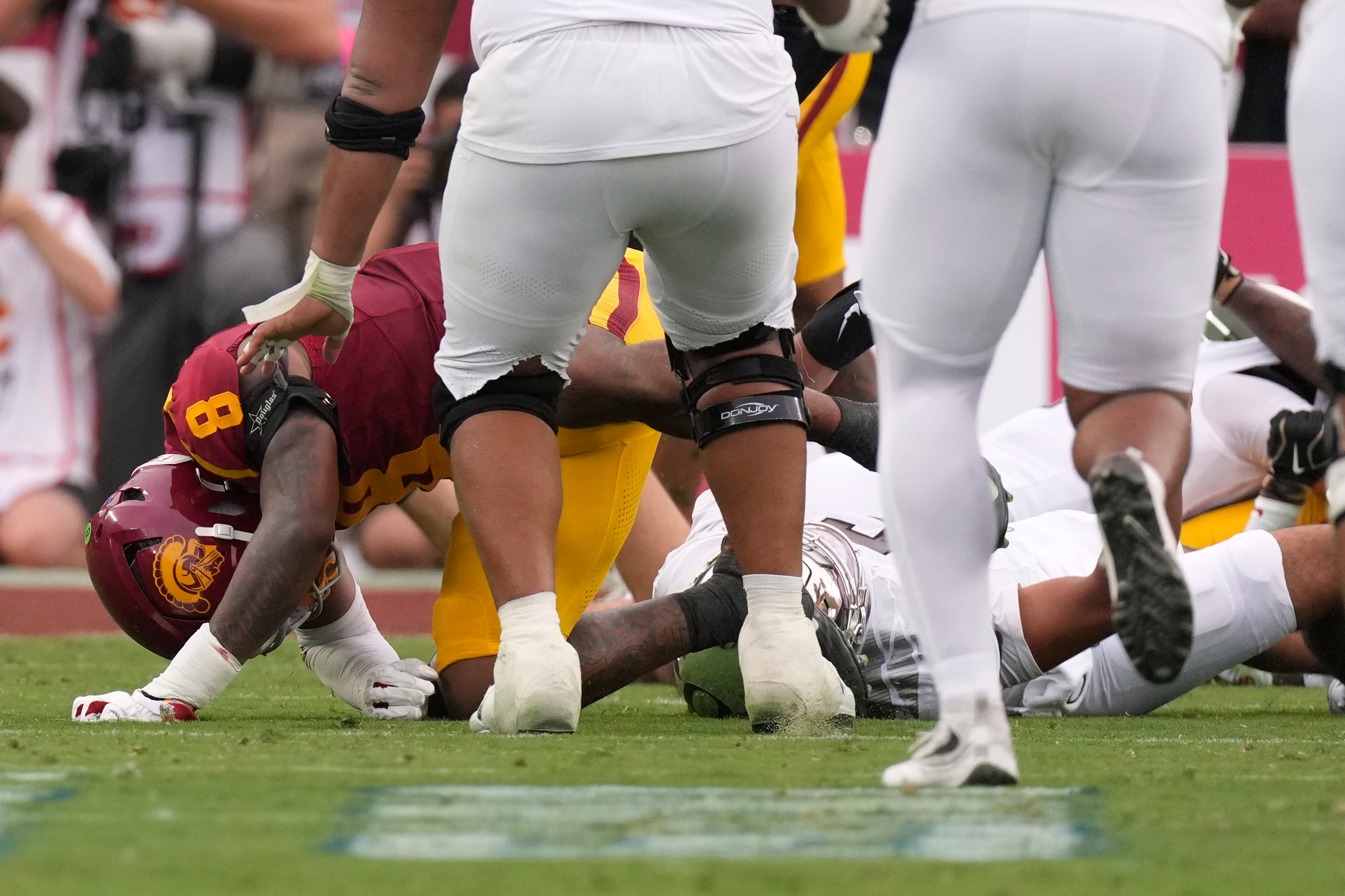 Oregon quarterback Dante Moore, bottom right, takes a hard tackle by Southern California linebacker Desman Stephens II (8) during the first half of an NCAA college football game, Saturday, Sept. 26, 2026, in Los Angeles. 