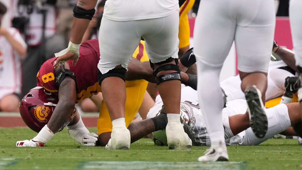 Oregon quarterback Dante Moore, bottom right, takes a hard tackle by Southern California linebacker Desman Stephens II (8) during the first half of an NCAA college football game, Saturday, Sept. 26, 2026, in Los Angeles.