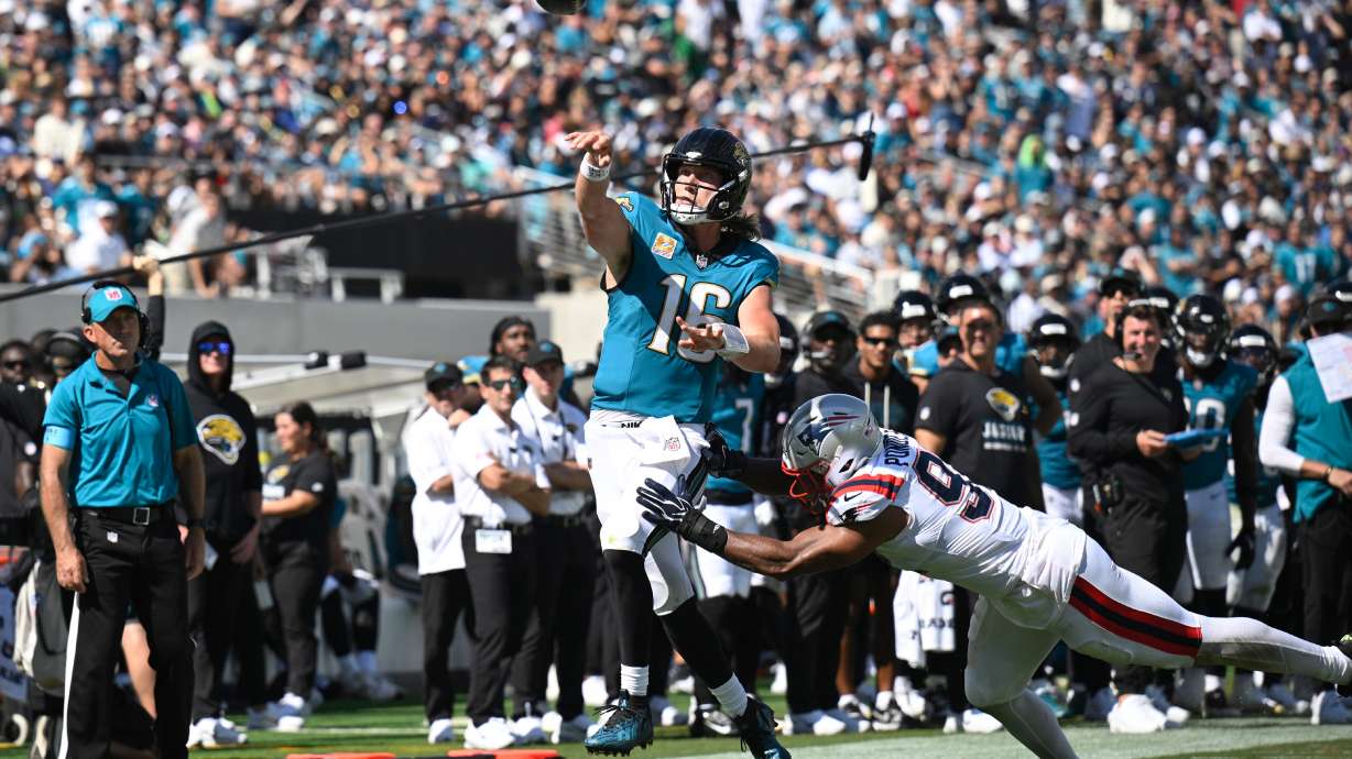 Jacksonville Jaguars quarterback Trevor Lawrence (16) passes against New England Patriots linebacker Elijah Ponder (91) in the second half during an NFL football game in Jacksonville, Fla., Sunday, Sept. 27, 2026.