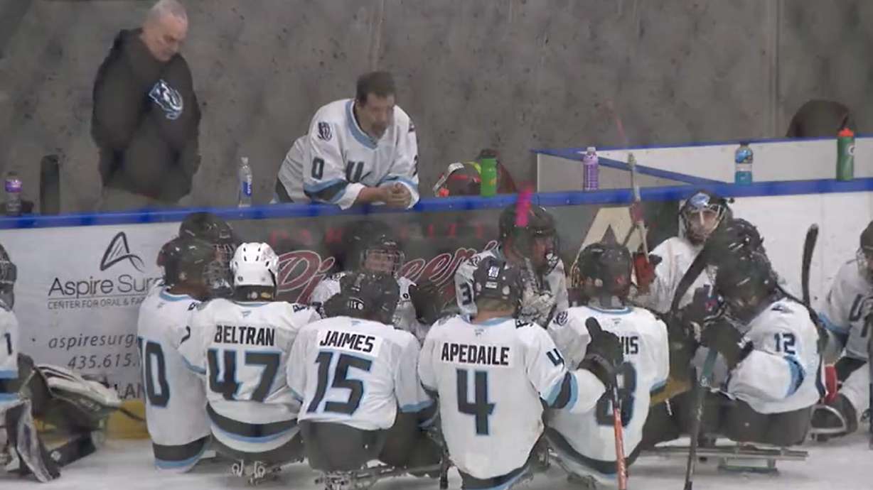 Coach Dave Nicholls (in white jersey) speaking to the Utah Mammoth sled hockey team on Sunday in Park City.