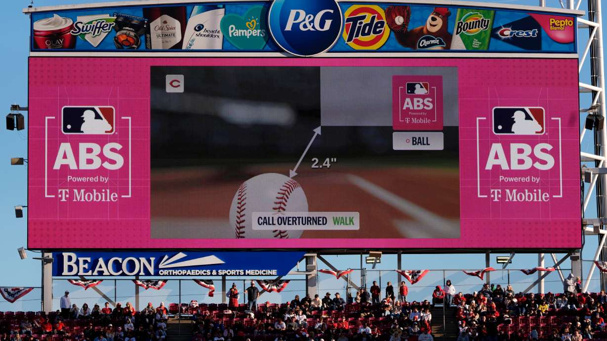 FILE - A call is overturned to a walk by the Automated Ball-Strike (ABS) Challenge System, displayed on the stadium screens, after Cincinnati Reds' Will Benson challenged at pitch result during the seventh inning of a baseball game against the Boston Red Sox in Cincinnati, March 28, 2026.